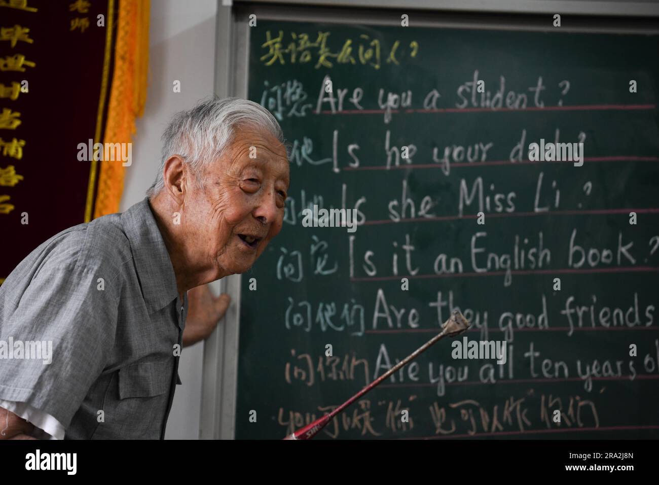 HEXIAN, 30 giugno 2023 (Xinhua) -- Ye Lianping dà una lezione di inglese alla "casa per i bambini lasciati dietro" nel villaggio di Buchen della contea di Hexian, nella provincia dell'Anhui della Cina orientale, 29 giugno 2023. YE Lianping, 95 anni, un insegnante in pensione, iniziò a dare lezioni di inglese gratuite nel 2000 quando istituì una "casa per bambini lasciati indietro" nel villaggio di Buchen. La maggior parte dei suoi studenti sono lasciati indietro nel villaggio mentre i loro genitori andavano a lavorare nelle città. Negli ultimi 23 anni, oltre 2.000 bambini hanno beneficiato delle classi di Ye. YE Lianping, vivere una vita semplice senza figli, passa la maggior parte del suo savi Foto Stock