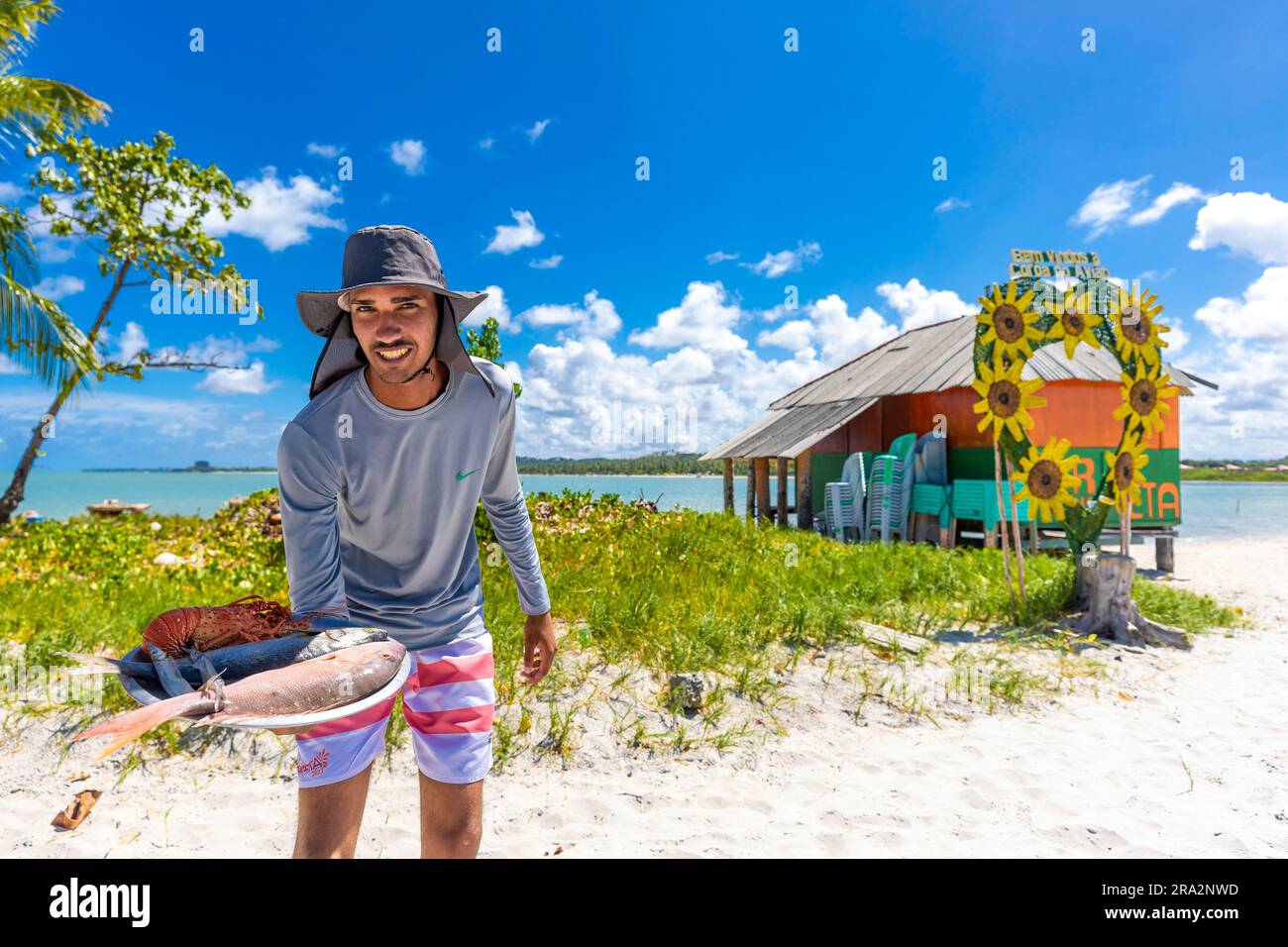 Brasile, Nordeste, Pernambuco, isola di Coroa do Avião, cameriere sulla spiaggia con pesce e aragosta Foto Stock