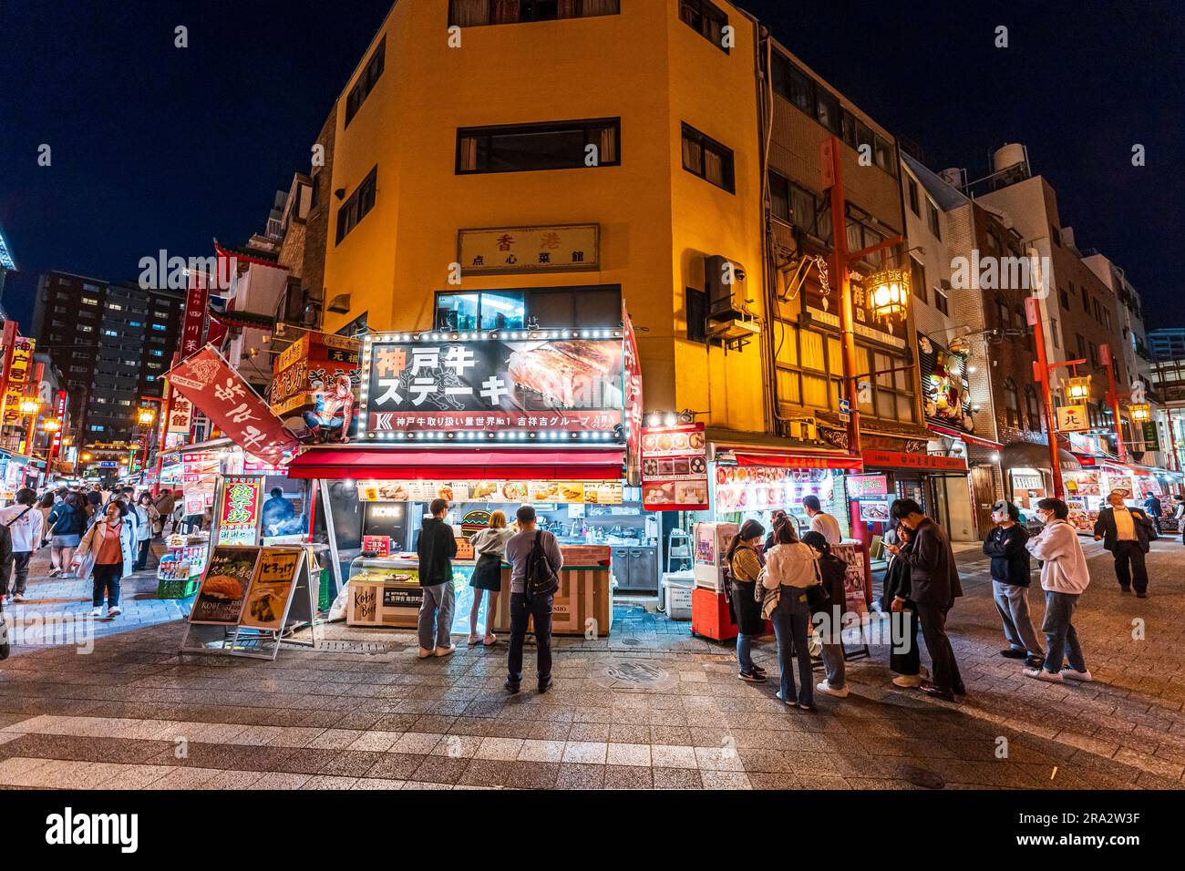 Vista notturna da ampio angolo di una popolare bancarella illuminata di carne di manzo Kobe all'angolo di Nankinmachi Square a Chinatown, Kobe. Foto Stock