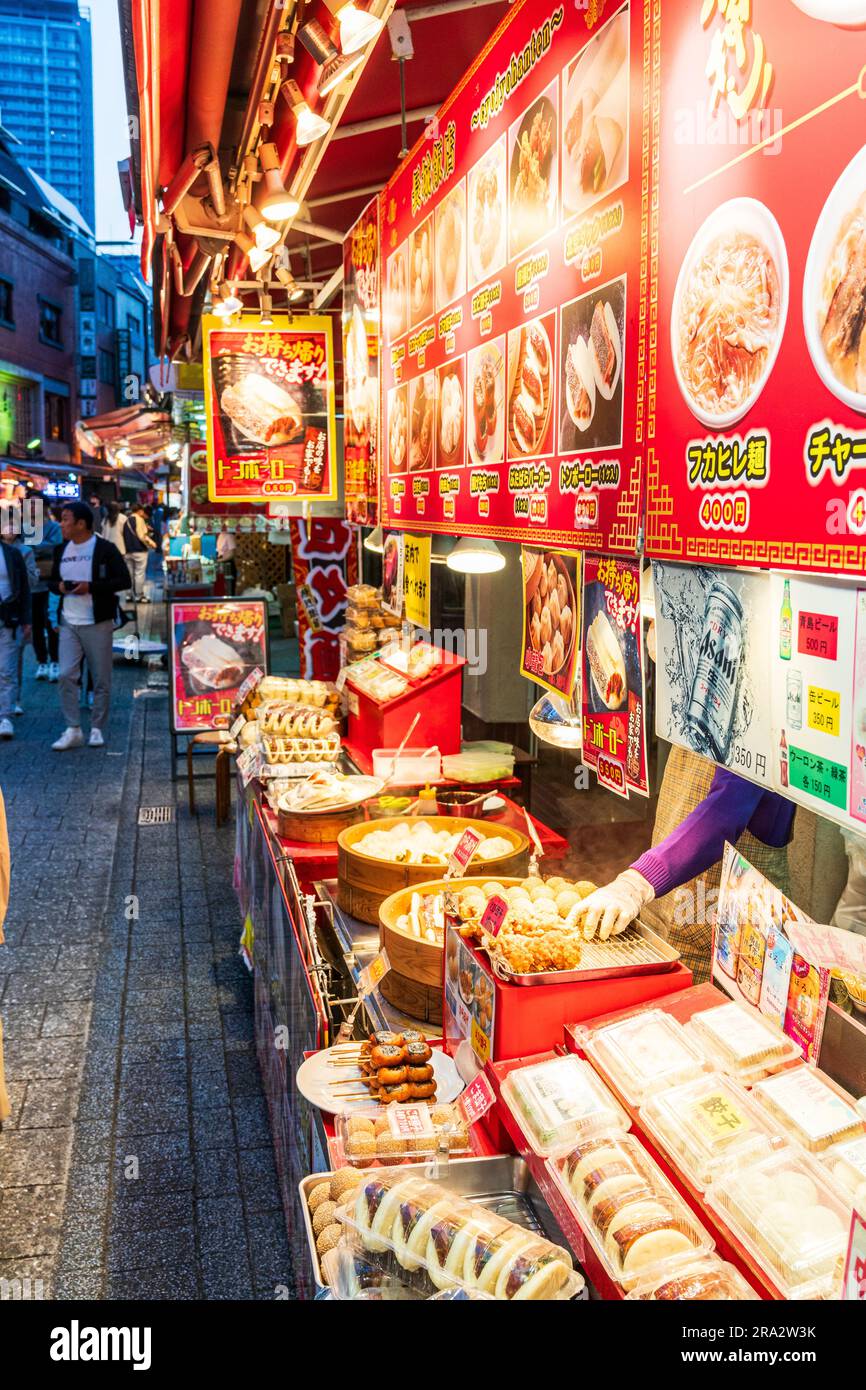 Bancarelle di cibo cinese da asporto che vendono panini e gnocchi cotti in contenitori di bambù, notte a Nankinmachi, Chinatown, Kobe. Foto Stock