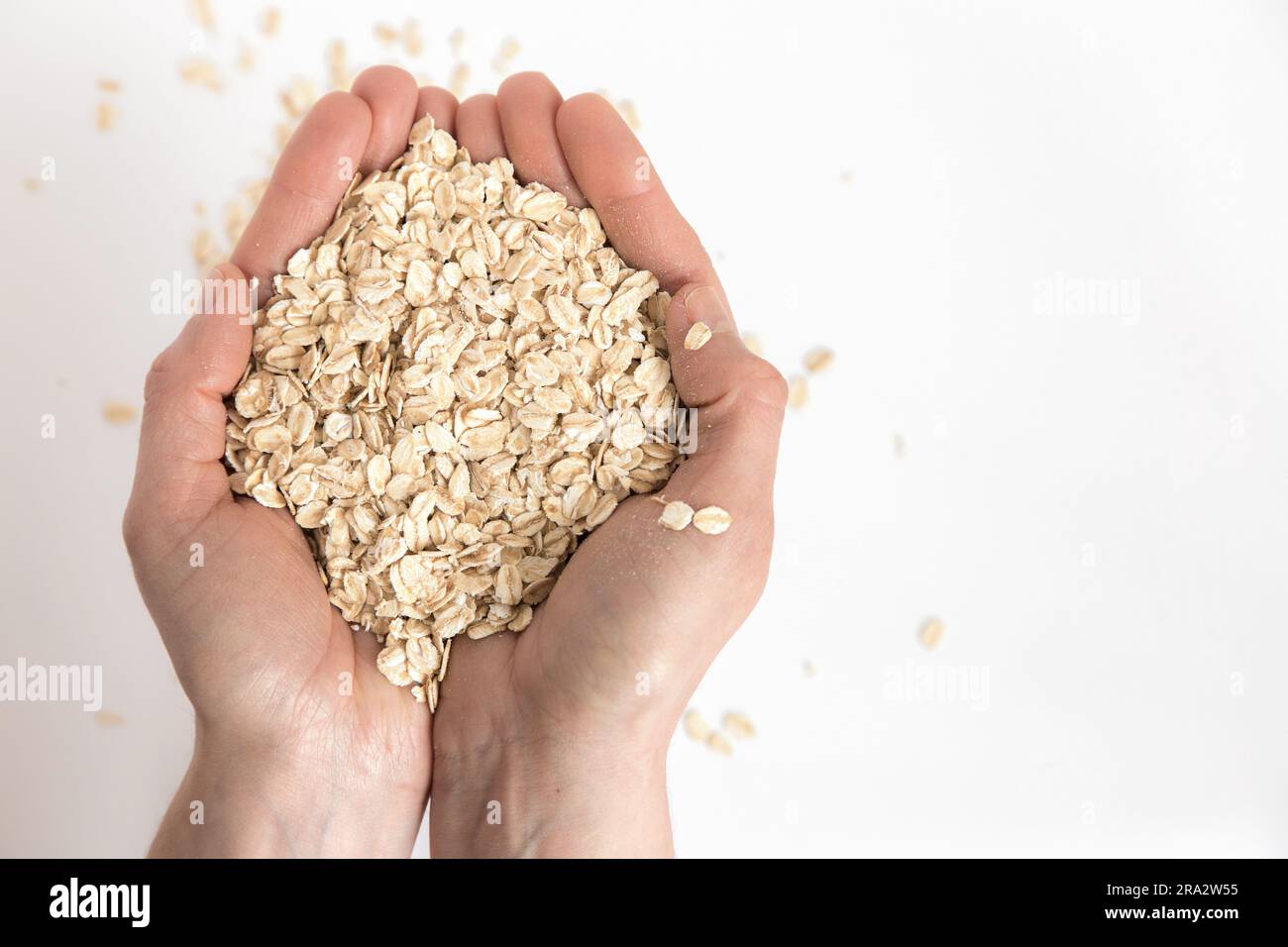 Mani piene di fiocchi d'avena su sfondo bianco. Alimenti super ricchi di sostanze nutritive che possono essere utilizzati per diverse ricette. Mangiare sano. Vista dall'alto e copia Foto Stock Mani piene di fiocchi d'avena su sfondo bianco. Alimenti super ricchi di sostanze nutritive che possono essere utilizzati per diverse ricette. Mangiare sano. Vista dall'alto e copia Foto Stock