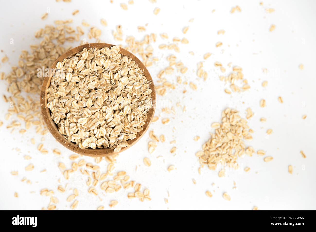 Recipiente in legno pieno di fiocchi d'avena su sfondo bianco. Alimenti super ricchi di sostanze nutritive che possono essere utilizzati per diverse ricette. Mangiare sano. Vista dall'alto. Foto Stock Recipiente in legno pieno di fiocchi d'avena su sfondo bianco. Alimenti super ricchi di sostanze nutritive che possono essere utilizzati per diverse ricette. Mangiare sano. Vista dall'alto. Foto Stock