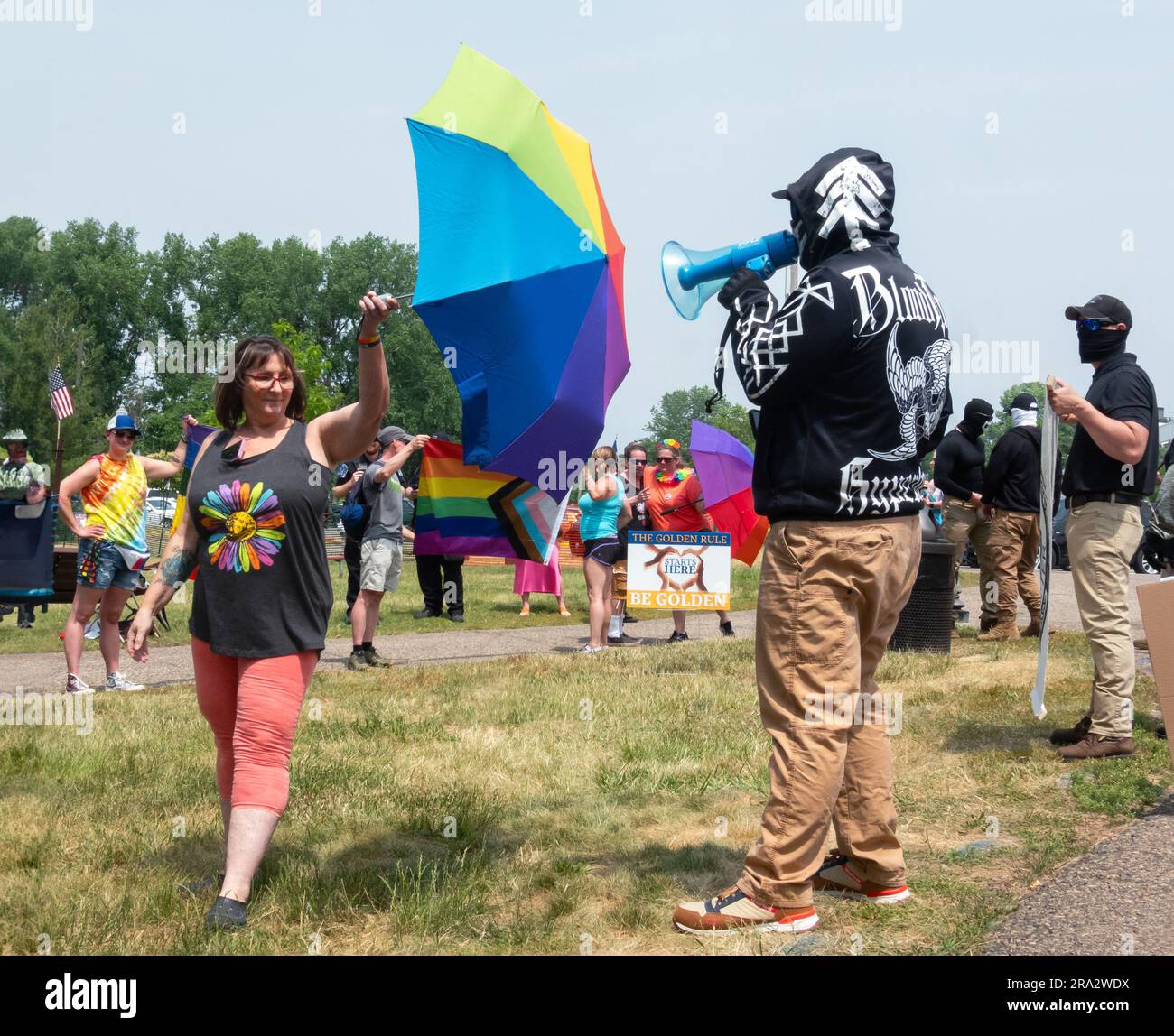 HUDSON, WISCONSIN, USA - 17 GIUGNO 2023: Manifestanti anti anti LGBTQ+ non identificati mascherati e partecipanti al festival alla celebrazione dell'Hudson Pride. Foto Stock