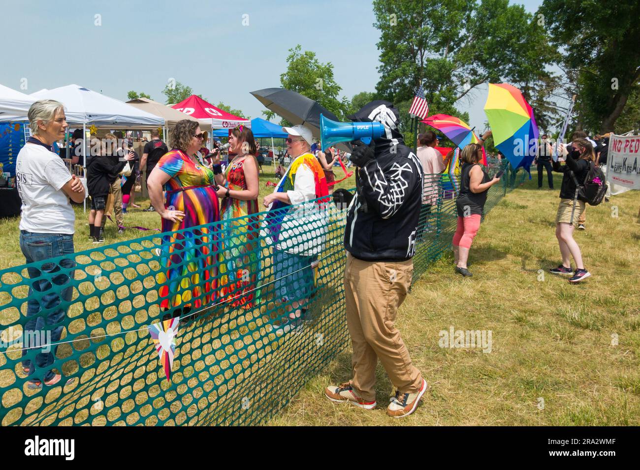 HUDSON, WISCONSIN, USA - 17 GIUGNO 2023: Manifestanti anti anti LGBTQ+ non identificati mascherati e partecipanti al festival alla celebrazione dell'Hudson Pride. Foto Stock