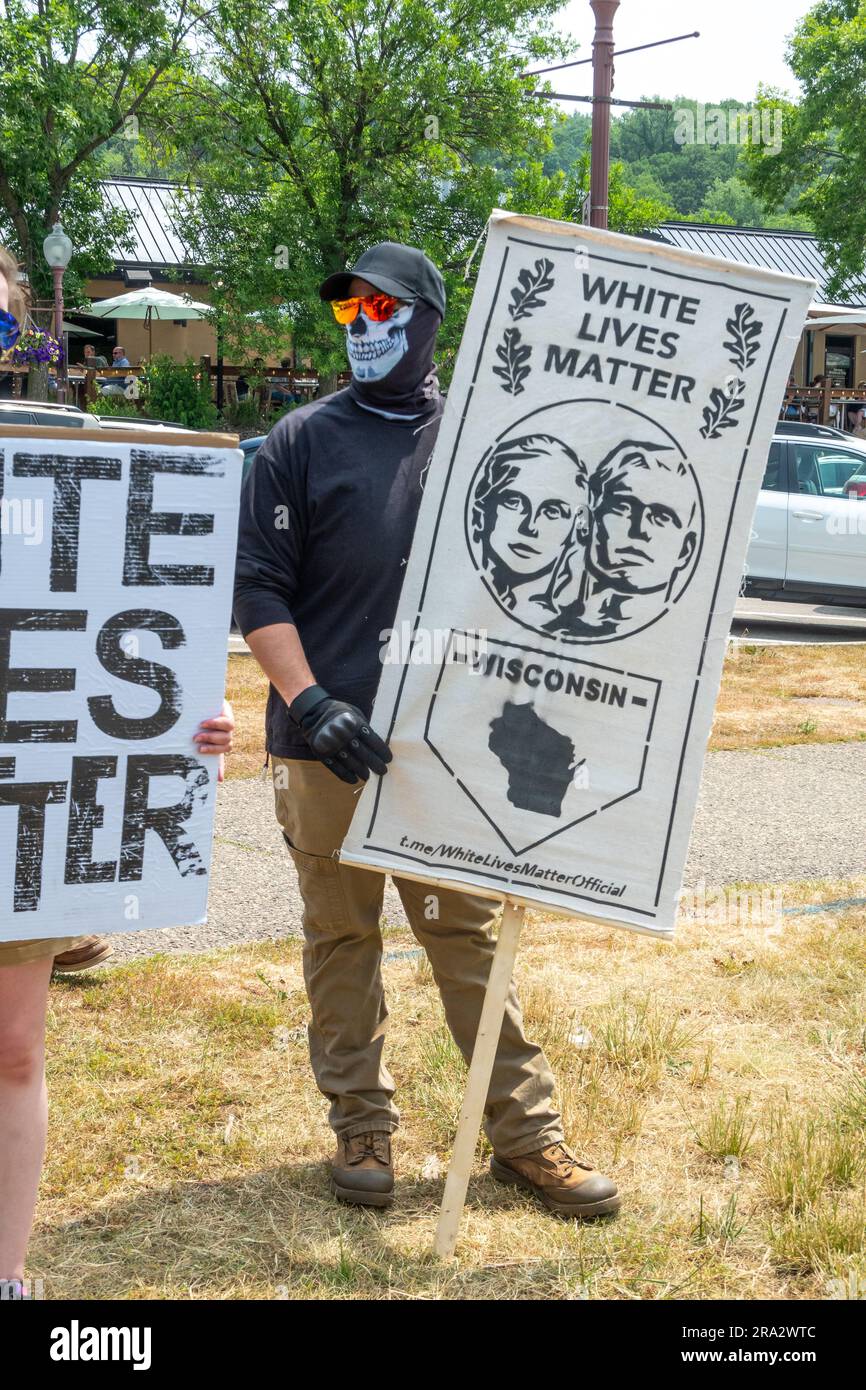 HUDSON, WISCONSIN, Stati Uniti d'America - 17 GIUGNO 2023: Individuo mascherato non identificato che tiene il banner White Lives Matter alla celebrazione dell'Hudson Pride. Foto Stock