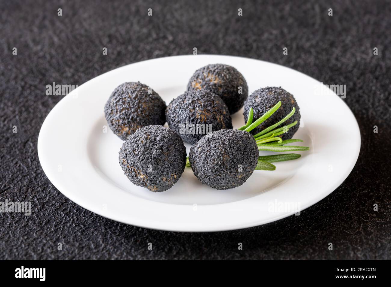 Palle di mozzarella impanate con tartufo nero sul piatto Foto Stock