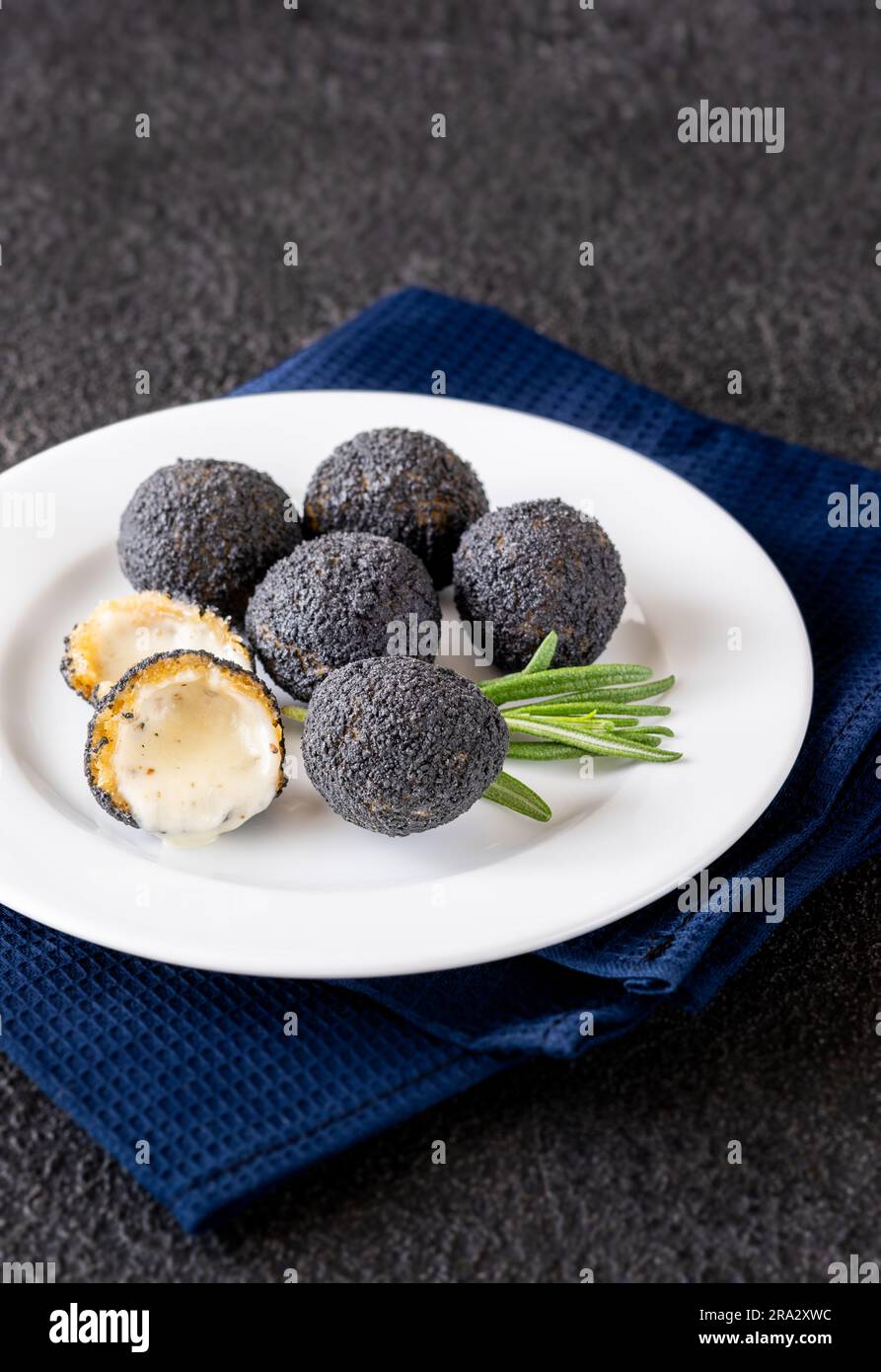 Palle di mozzarella impanate con tartufo nero sul piatto Foto Stock