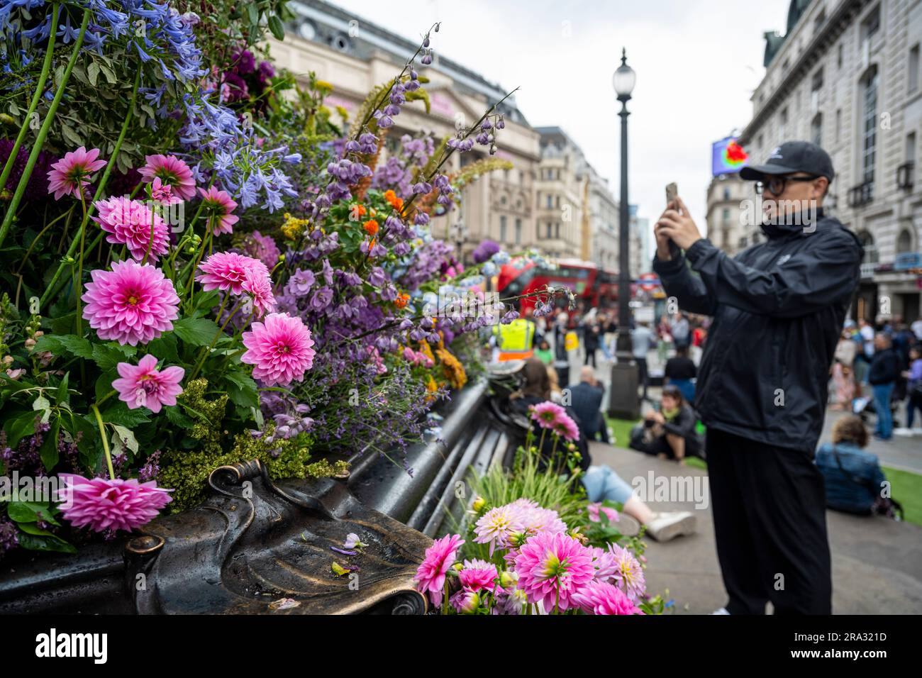 Londra, Regno Unito. 30 giugno 2023. Il pubblico accanto a 6.000 fiori e piante che sono stati installati sulla fontana commemorativa di Shaftesbury sotto la statua di Eros in coincidenza con una nuova installazione video artistica pubblica, intitolata «Sparks of Nature» dell'artista Amelia Kosminsky, esposta di notte (il 29 e 30 giugno) Sugli schermi giganti di Piccadilly Circus per celebrare il ritorno del programma artistico stagionale di Londra in tarda serata. Crediti: Stephen Chung / Alamy Live News Foto Stock