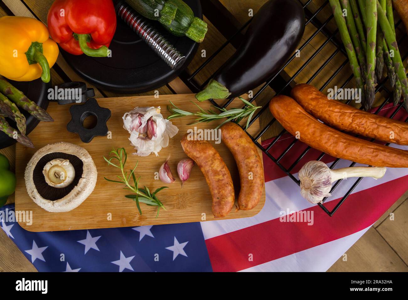 Manubri da palestra, cibo e bandiera degli Stati Uniti d'America. Concezione del barbecue per festeggiare il 4 luglio il giorno dell'indipendenza negli Stati Uniti. Foto Stock