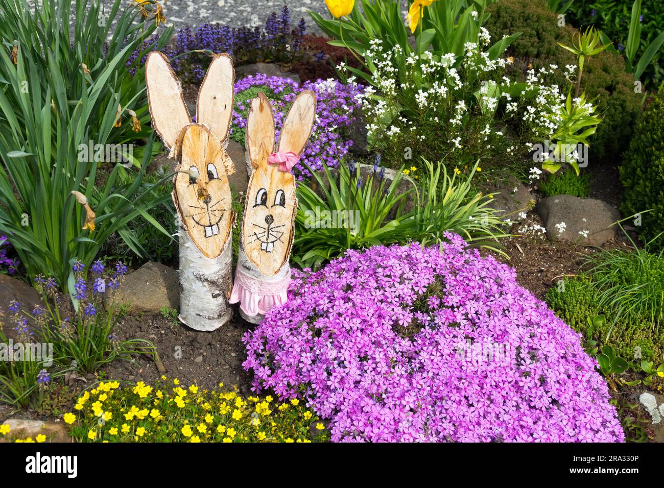 Due coniglietti nel giardino, coniglietti primaverili coppia Spring Flowers Garden Foto Stock