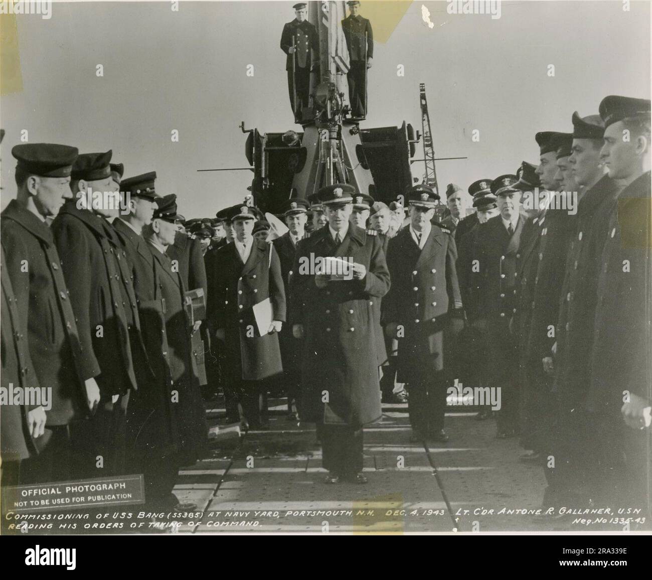 Messa in servizio della USS Bang. Didascalia originale: Messa in servizio della USS Bang presso Navy Yard, Portsmouth, N.H. 4 dicembre 1943, tenente c'dr. [sic] Antone R. Gallaher, U.S.N. leggendo i suoi ordini di prendere il comando... 1943-12-04T00:00:00. Foto Stock