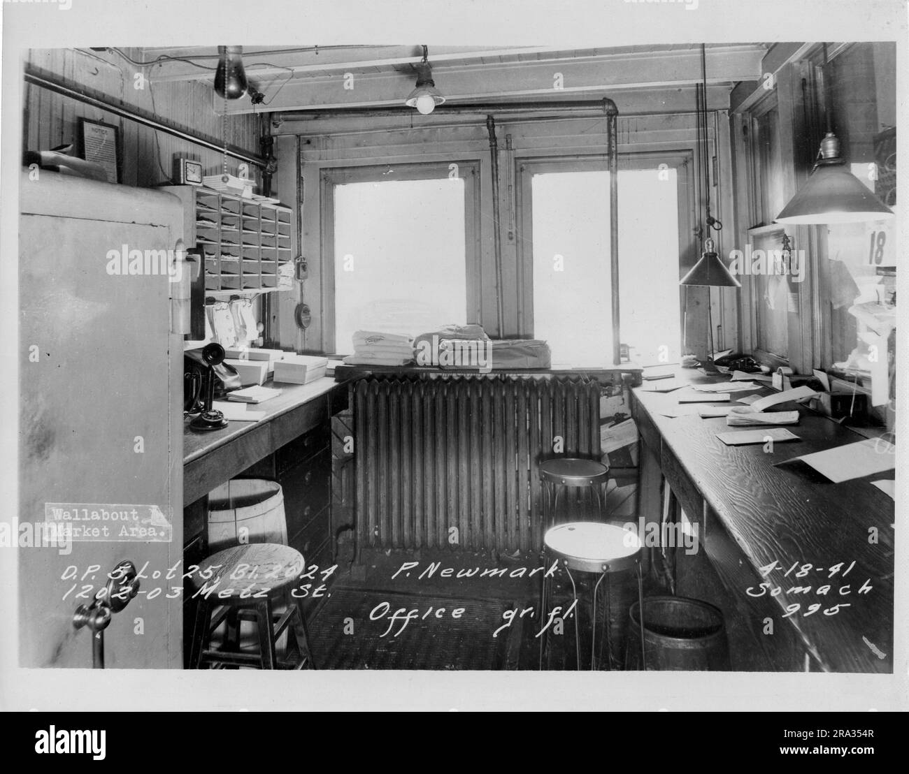 Fotografia dell'interno Wallabout Market, D.P. 5, lotto 25, Building 2024-P.Newmark, 1202-03 Metz St. Ufficio, gr. fil. Vista della camera dell'ufficio con banchi in legno, sgabelli alti, telefono con candelabro, cassaforte, radiatore e lampade a sospensione, dal negativo 995. Foto Stock Fotografia dell'interno Wallabout Market, D.P. 5, lotto 25, Building 2024-P.Newmark, 1202-03 Metz St. Ufficio, gr. fil. Vista della camera dell'ufficio con banchi in legno, sgabelli alti, telefono con candelabro, cassaforte, radiatore e lampade a sospensione, dal negativo 995. Foto Stock