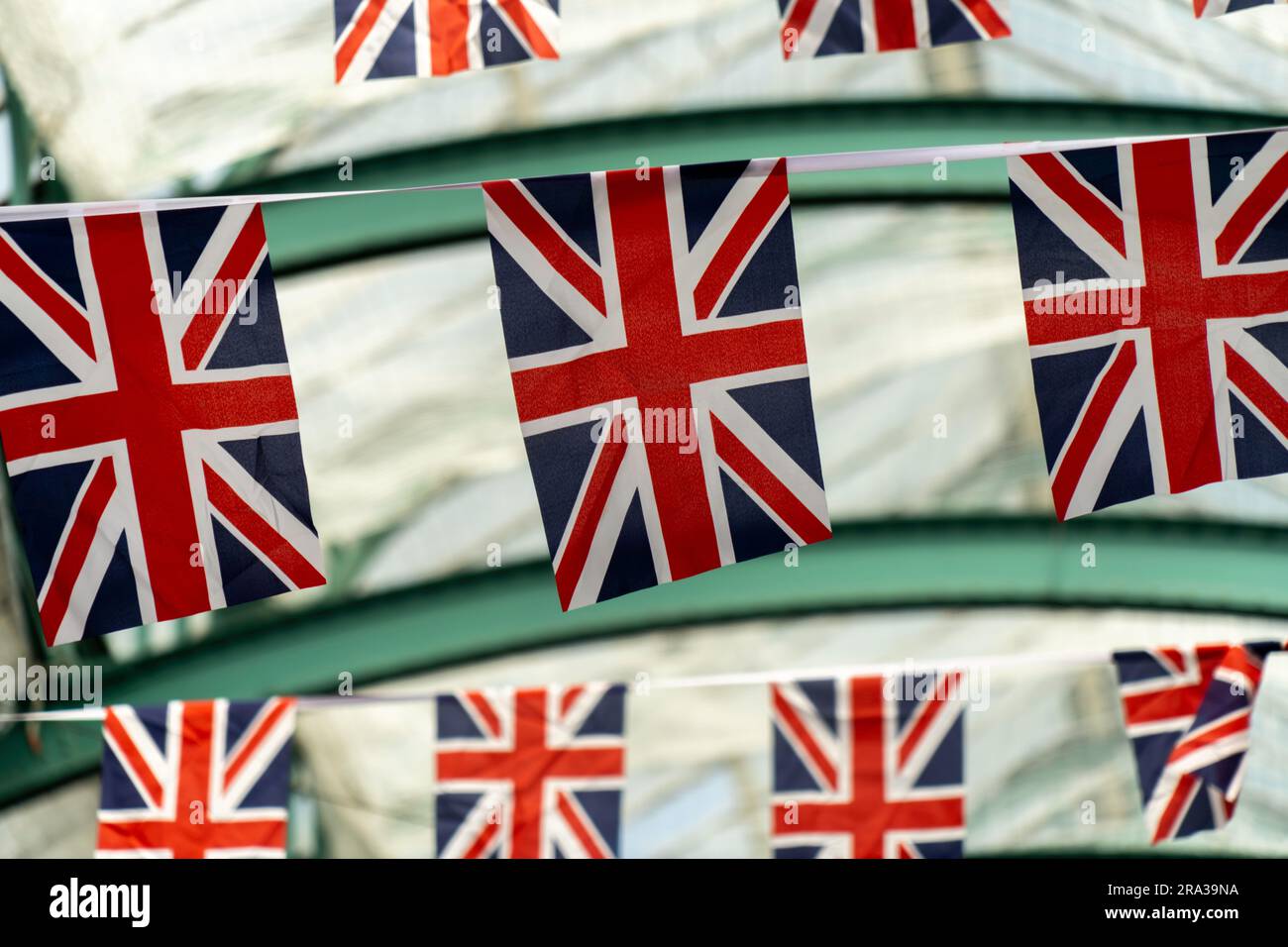 Bandiere inglesi appese a Covent Garden, un popolare mercato all'aperto di Londra con negozi, ristoranti e bar. Primo piano delle bandiere Union Jack che si fanno bunting, che volano. Foto Stock