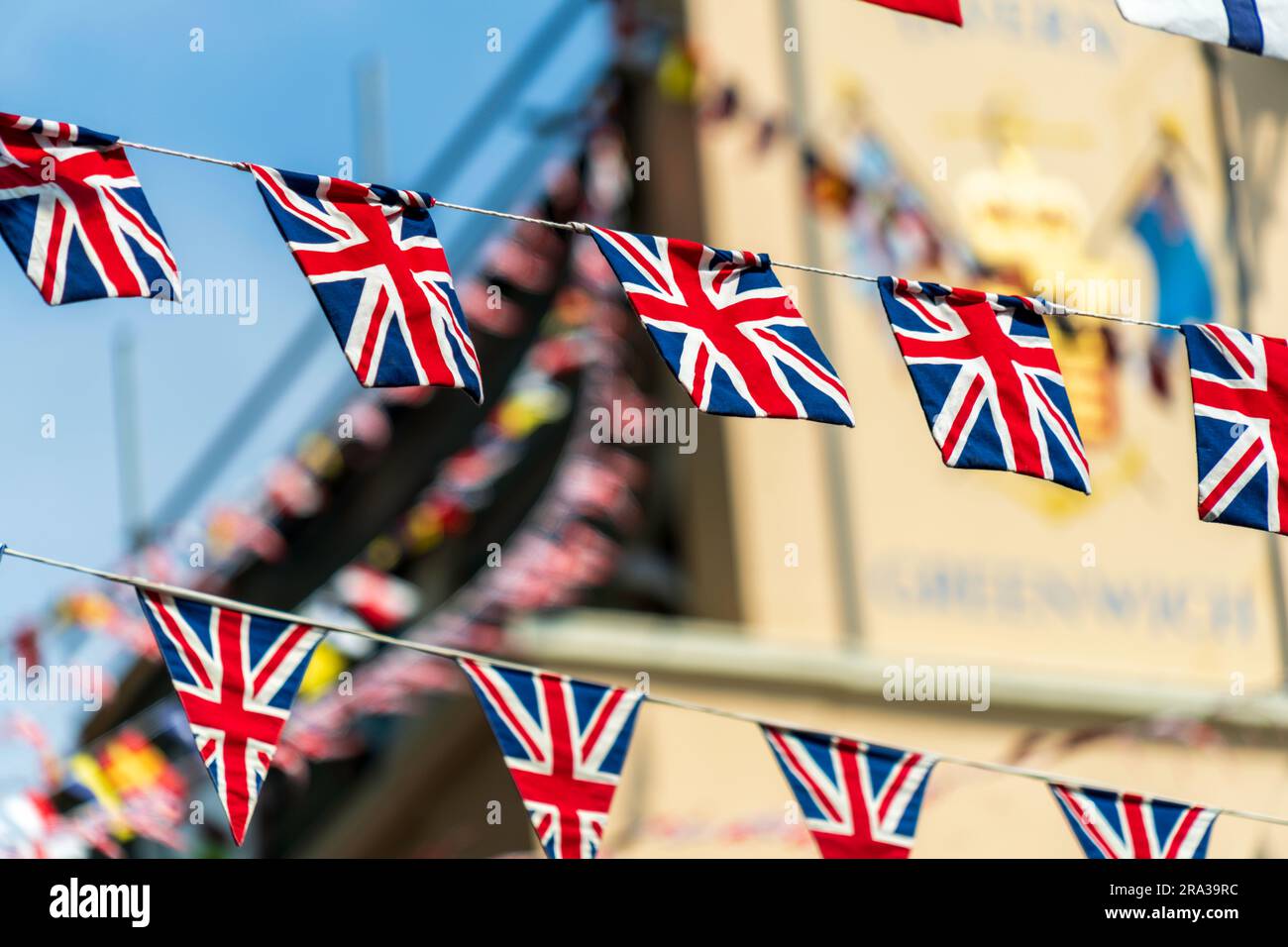 Le bandiere Union Jack del Regno Unito decorano una strada di Greenwich, Londra, sopra un pub inglese. L'iconica bandiera decorativa del Regno Unito è festosa e fa parte della cultura inglese. Foto Stock