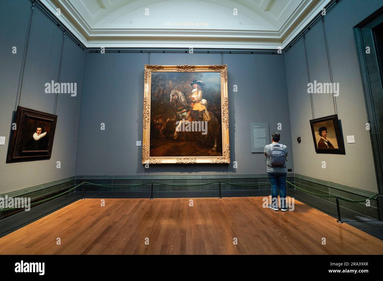 La National Gallery di Londra, un uomo che legge la descrizione di un dipinto di Rembrandt, un capolavoro. Il museo d'arte si trova a Trafalgar Square. Foto Stock