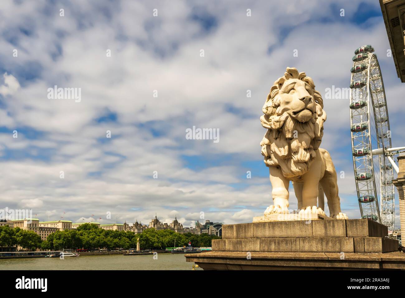 Paesaggio urbano di Londra con il South Bank Lion, gli edifici cittadini, il Tamigi e il London Eye che si affaccia sul Westminster Bridge in una giornata di sole con nuvole, Foto Stock