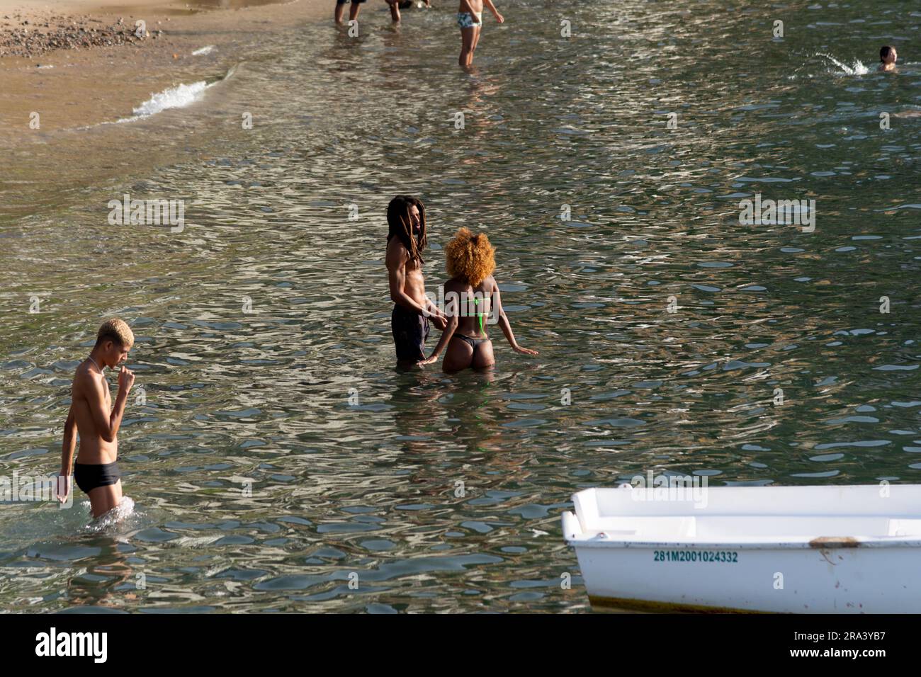 Salvador, Bahia, Brasile - 14 gennaio 2022: Si vedono le persone nuotare in mare e prendere il sole sulle sabbie della spiaggia nella comunità Gamboa di Sal Foto Stock