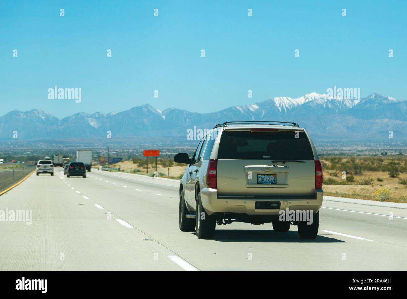 California, USA - aprile 2017: Autostrada americana con auto. La strada si estende in lontananza sullo sfondo di montagne. Guida in auto lungo l'autostrada, vista posteriore Foto Stock