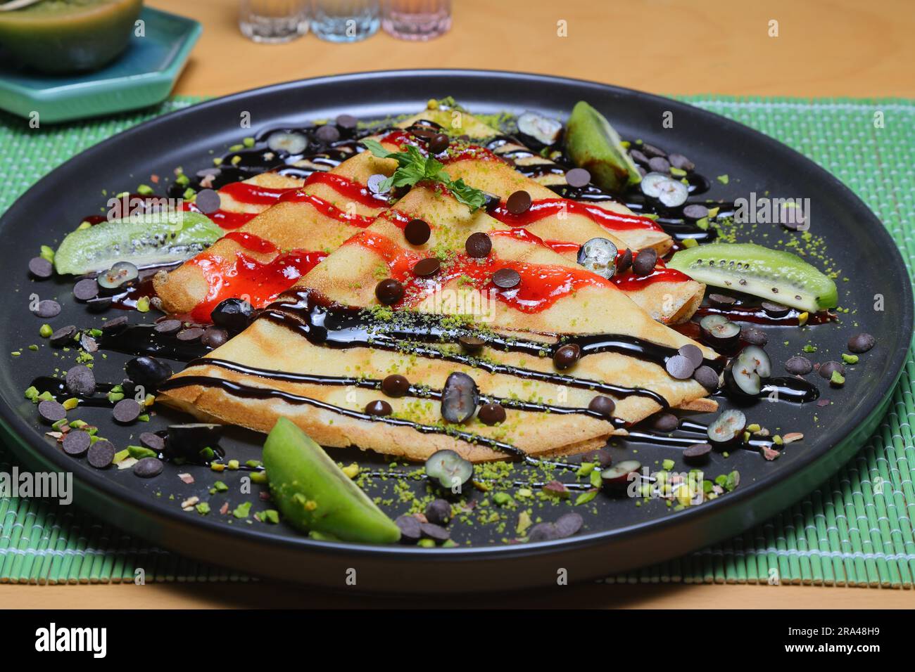 Crepes sottili fatte in casa con crema di cioccolato e nocciole per colazione o dessert. banner, menu, posizione ricetta per il testo, vista dall'alto. Foto Stock