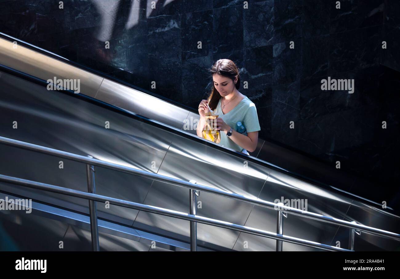 Belgrado, Serbia - 15 giugno 2022: Ragazza adolescente che sale sulla scala mobile della metropolitana, in una giornata di sole Foto Stock