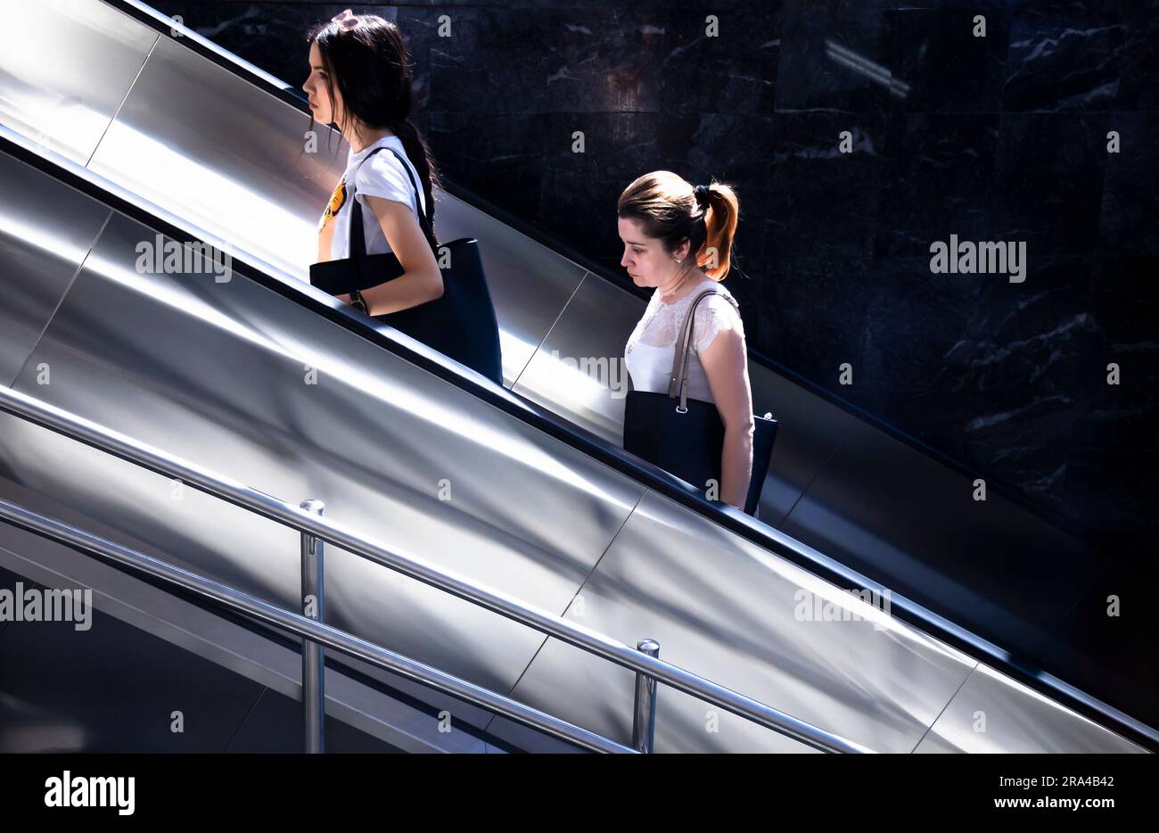 Belgrado, Serbia - 15 giugno 2022: Due donne che salgono sulla scala mobile della metropolitana, in una giornata di sole Foto Stock