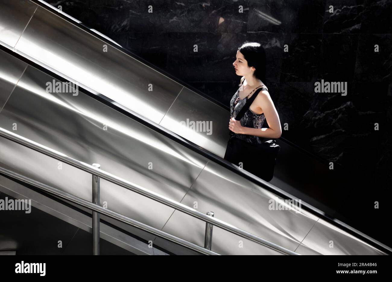 Belgrado, Serbia - 15 giugno 2022: Una giovane donna sale sulla scala mobile della metropolitana, in una giornata di sole Foto Stock