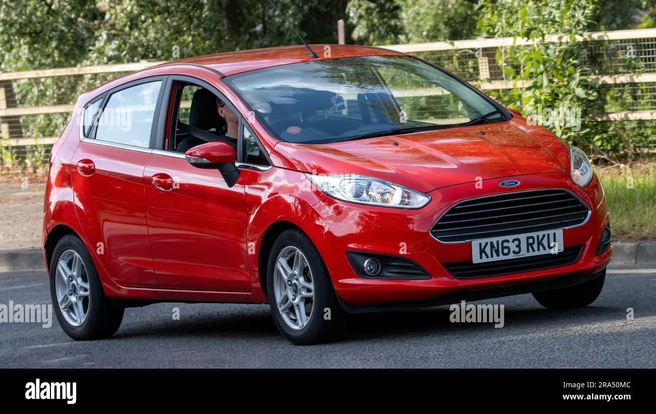 Milton Keynes, Regno Unito - 24 giugno 2023. 2013 auto FORD FIESTA ZETEC rossa che viaggia su una strada di campagna inglese Foto Stock