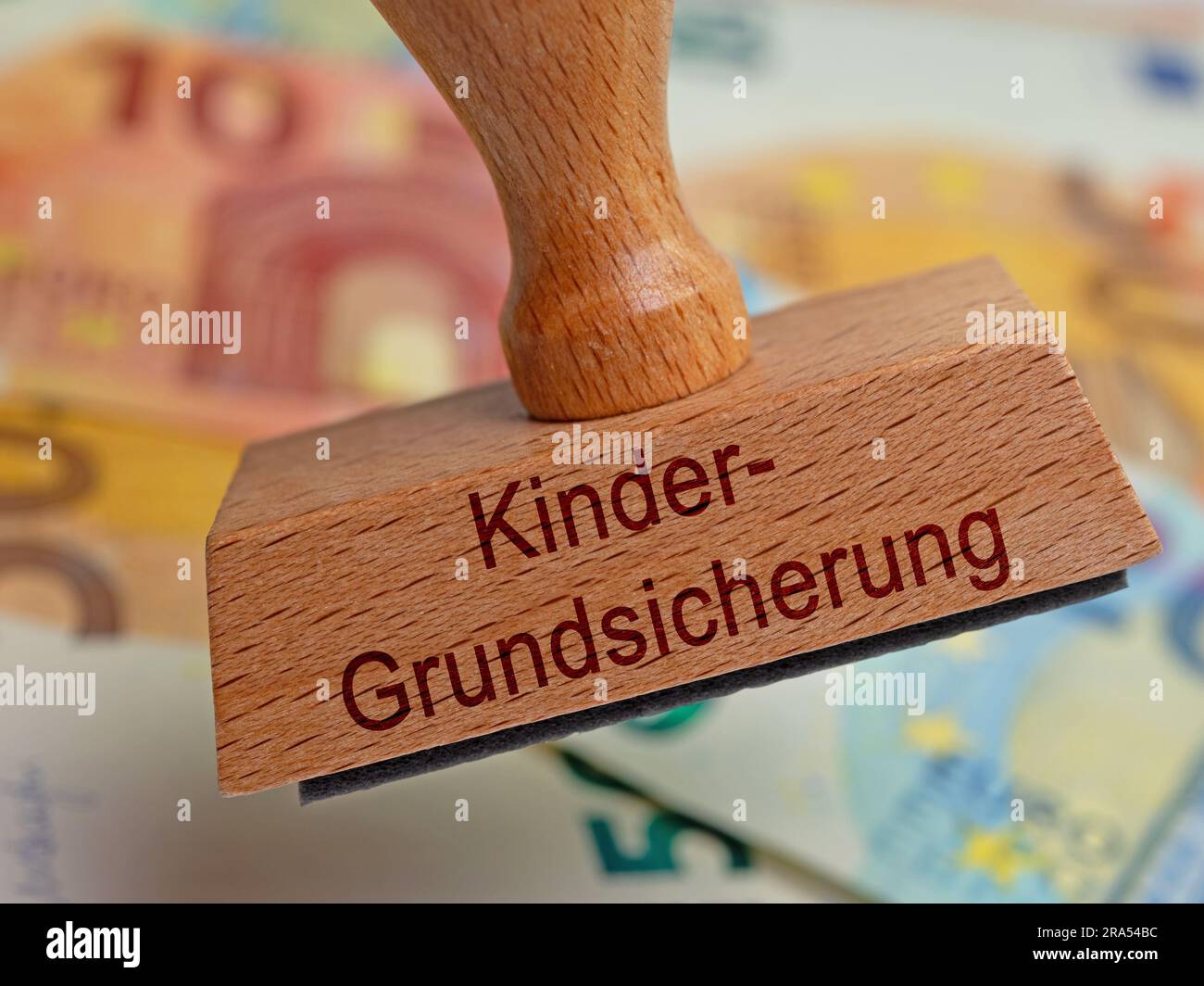 Timbro in legno con l'impronta "Kindergrundsicherung", traduzione "sicurezza di base per bambini" Foto Stock