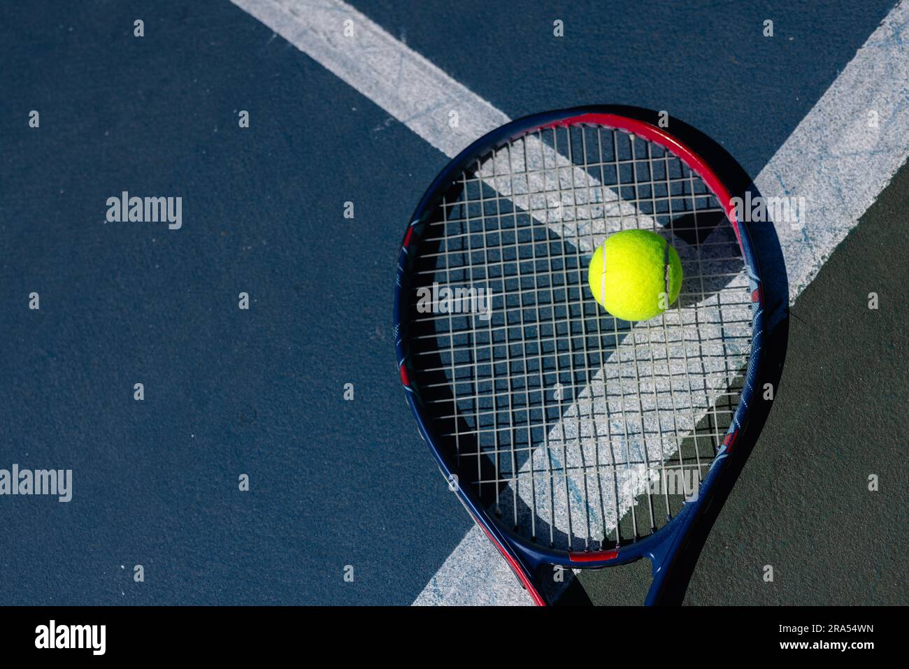 Sopra la palla da tennis e la racchetta da tennis sdraiati sul campo da tennis nelle giornate di sole, spazio fotocopie Foto Stock