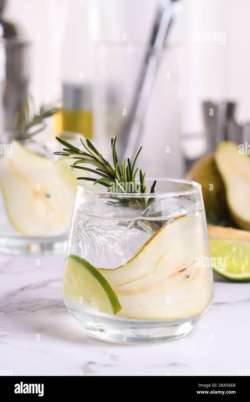 Cocktail gin con lime, rosmarino, pera matura e tonico. Questa bevanda rinfrescante e biologica è ricca di sapori vibranti ed erbe aromatiche. Foto Stock
