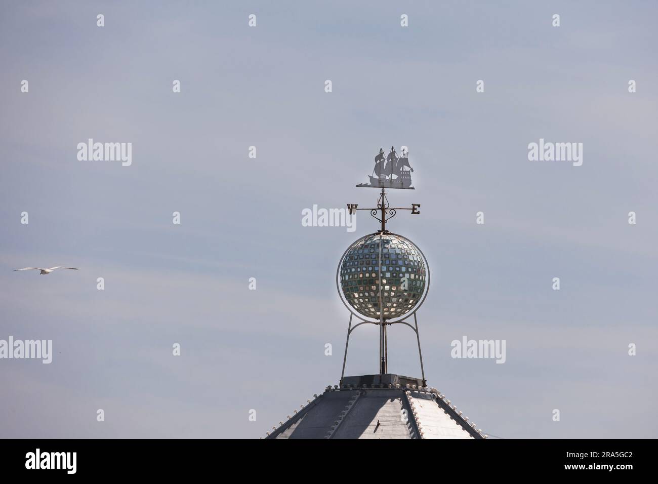 Bussola decorativa che mostra una nave in metallo e le indicazioni stradali su un tetto sul molo Palace, Brighton, Regno Unito Foto Stock