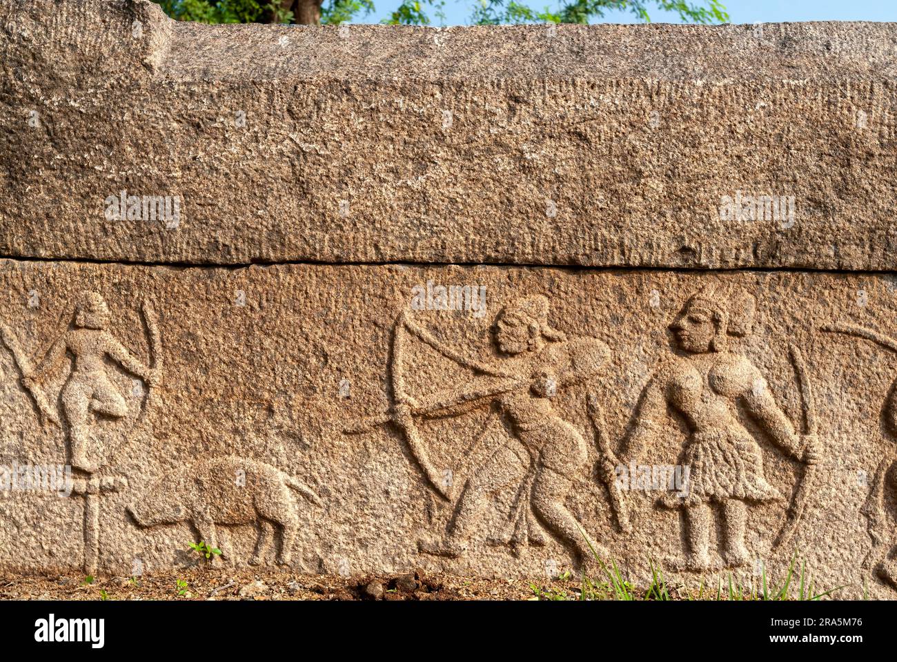 Sculture in bassorilievo di un uomo che mira a un maiale raffigurata parete parapetale del carro armato cinese Oorani vicino a Thiruvannamalai Tiruvannamalai, Tamil Nadu, Sud Foto Stock