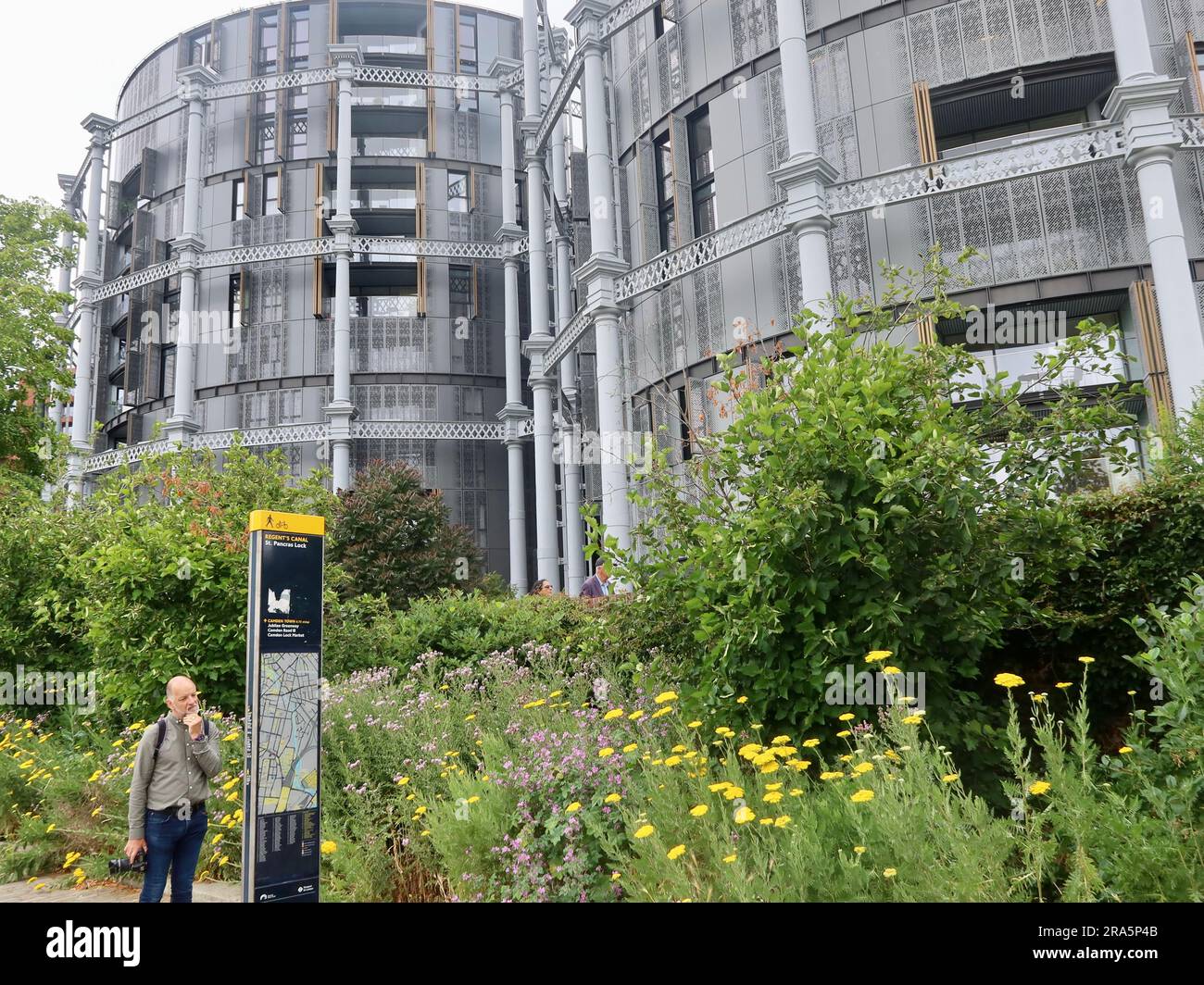 Londra, Regno Unito - giugno 2023 : complesso di appartamenti Gasholders accanto al Regents Canal. Uomo che legge la mappa e sembra perso. Foto Stock