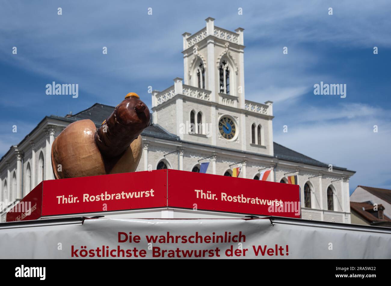Bancarella del mercato che pubblicizza la Turingia Rostbratwurst, dietro di esso storico municipio neogotico, piazza del mercato, Weimar, Turingia, Germania Foto Stock