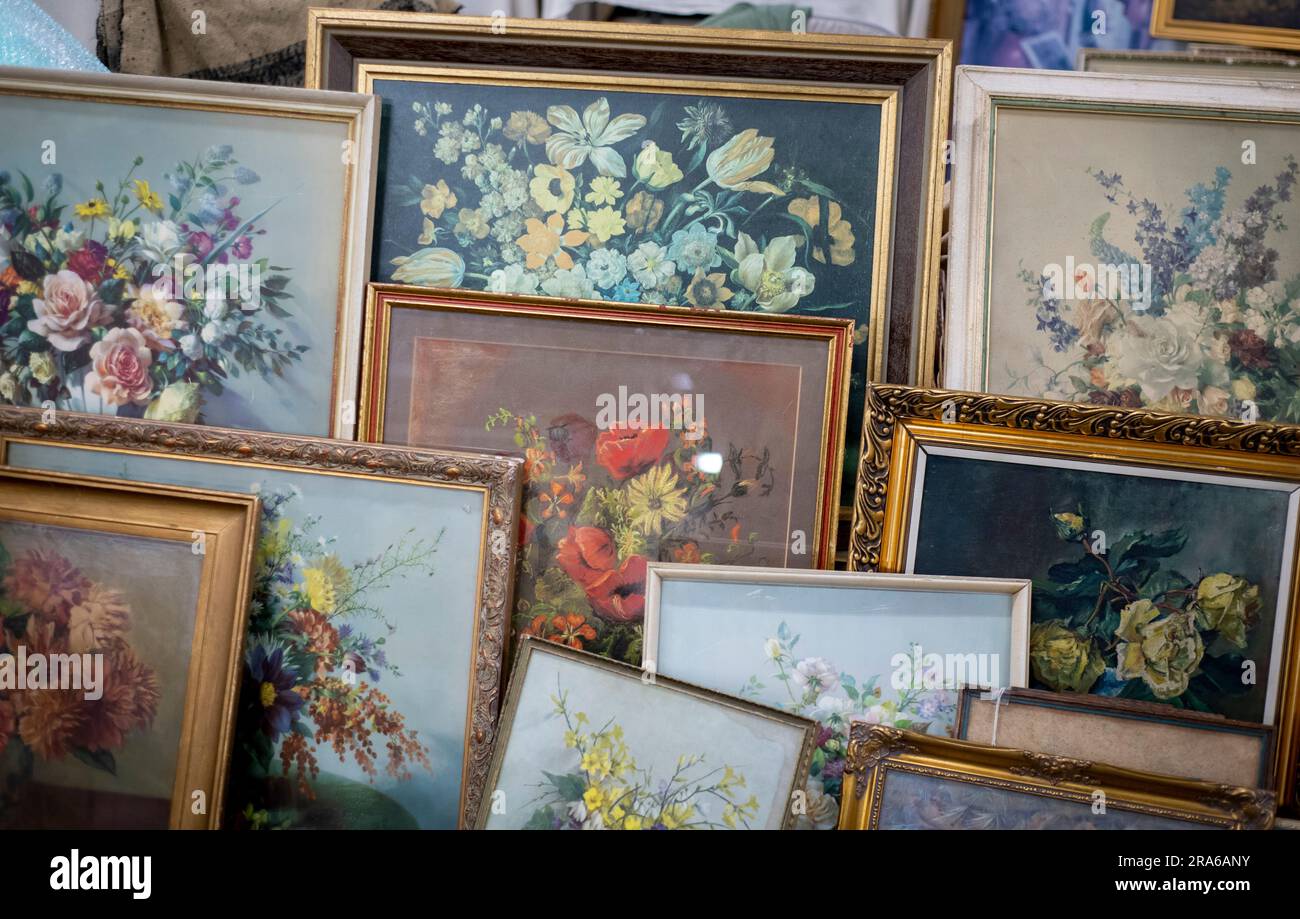 Una selezione di dipinti di fiori kitch al mercato mensile dell'antiquariato del Wembley Park, l'ultimo mercoledì del mese Foto Stock