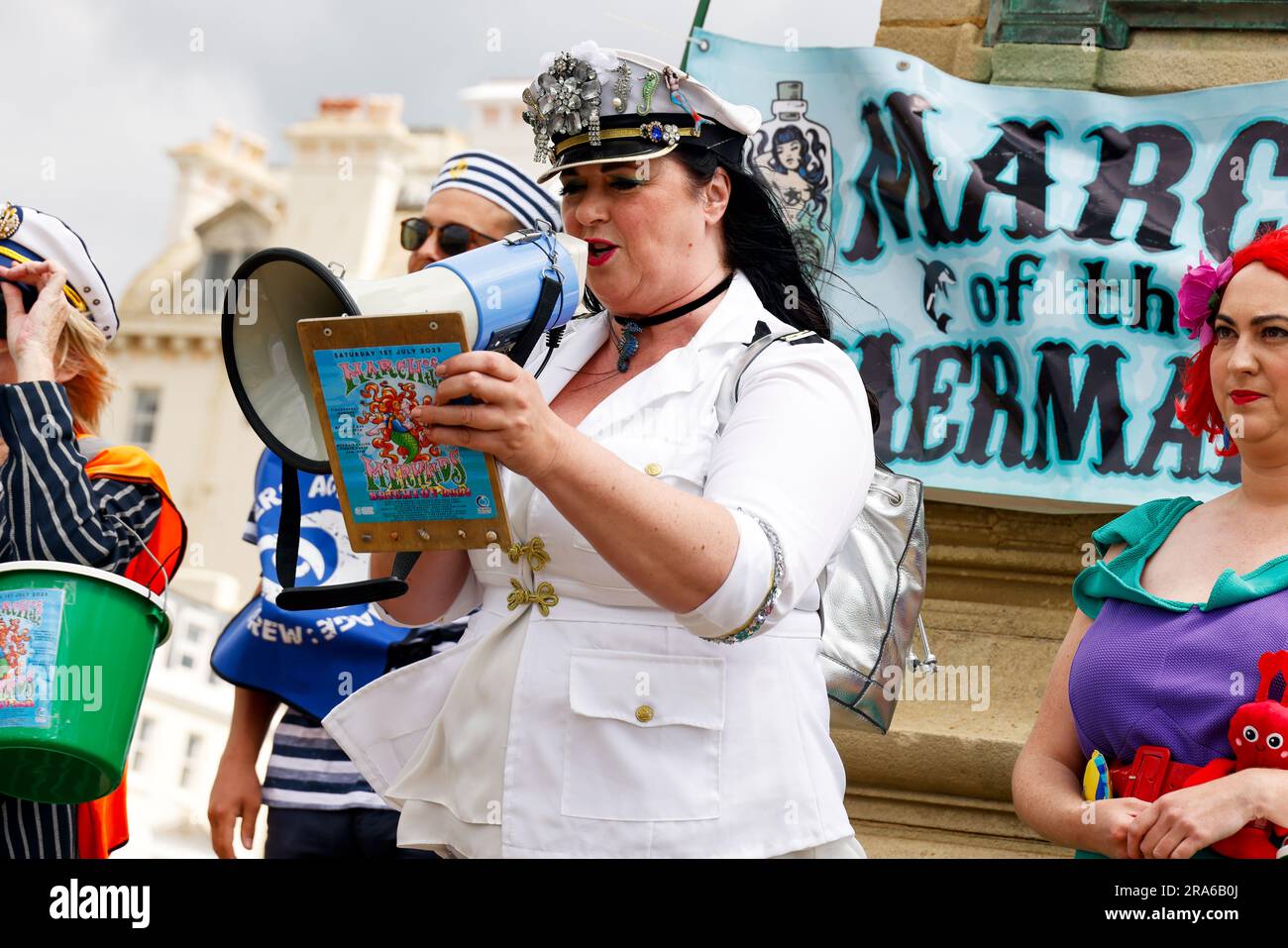 City of Brighton & Hove Seafront, East Sussex, Regno Unito. March of the Mermaids Marine Environmental Campaign Group che si allea con Surfers Against Sewage Annual Parade lungo il lungomare di Brighton, evidenziando la conservazione marina sulla costa meridionale dell'Inghilterra. Honour Mission, organizzatore che parla prima della marcia. 1 luglio 2023 crediti: David Smith/Alamy Live News Foto Stock