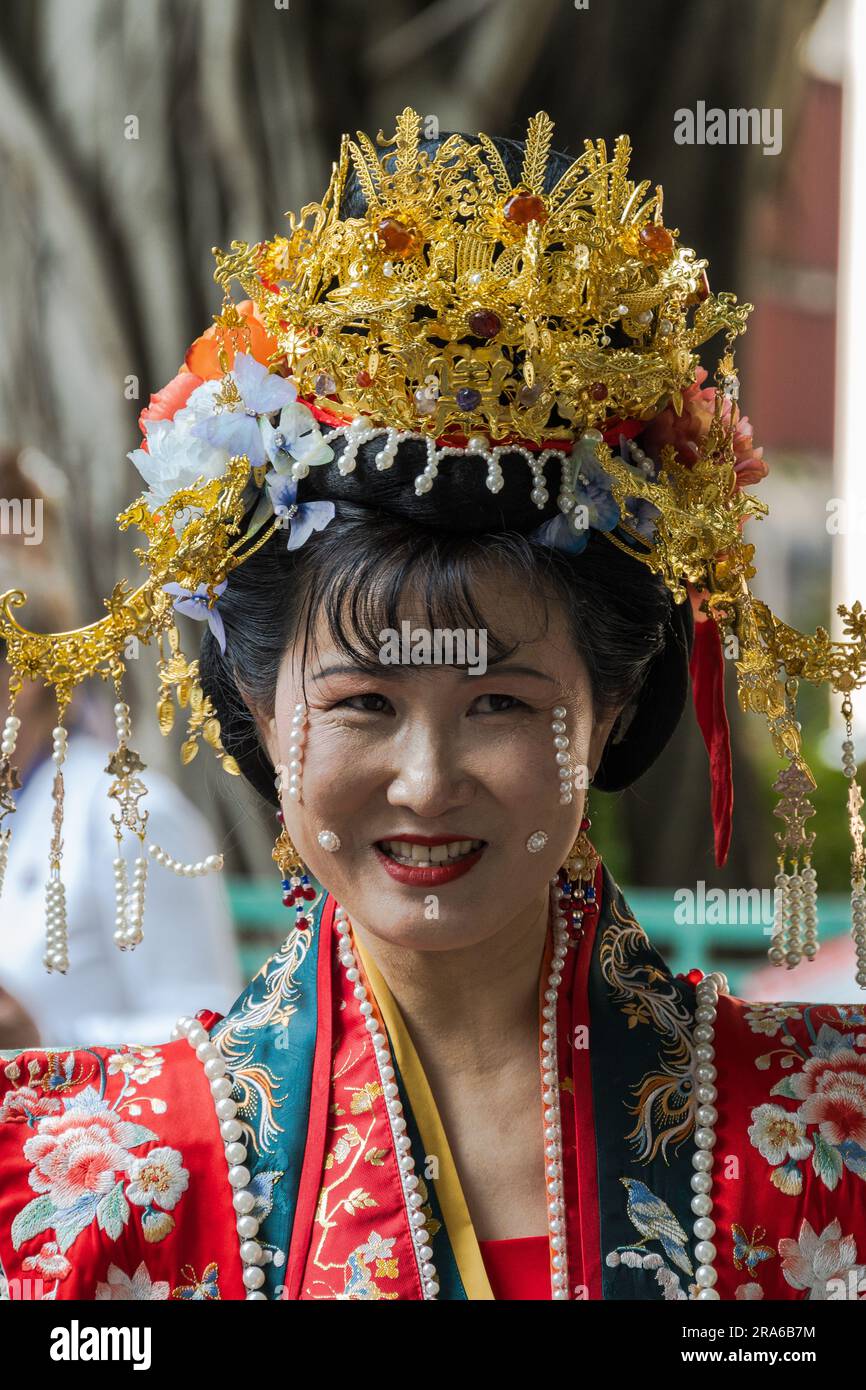 Hong Kong, Cina -- 11 marzo 2023. Ritratto di una donna che indossa un abito da sposa rosso e Gold Crown Foto Stock