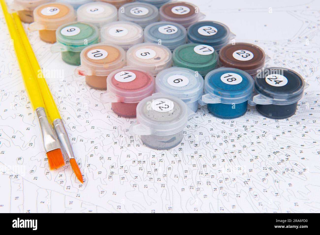 Insegnamento di disegno per bambini con pitture e pennelli colorati su sfondo bianco Foto Stock