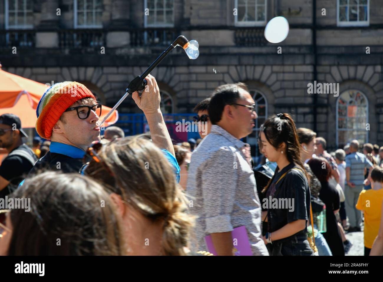 Street Artist Blowing Bubbles on the Royal Mile, Edimburgo durante il Festival di Edimburgo Foto Stock