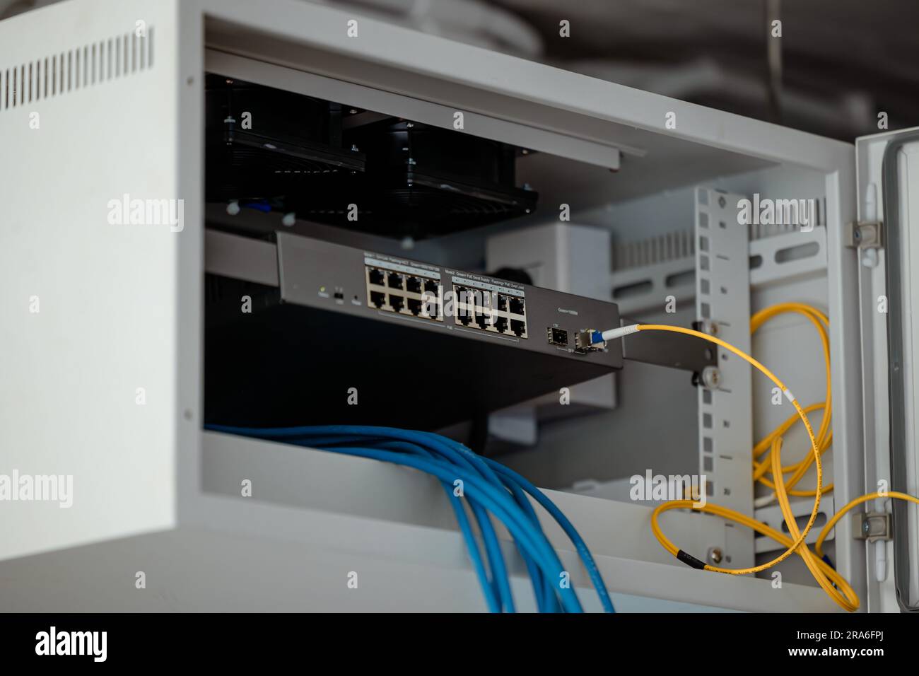 Switch di rete LAN a rack singolo in armadietto per l'installazione del sito di collegamento per la condivisione di Internet con fibra ottica gigabit. Foto Stock