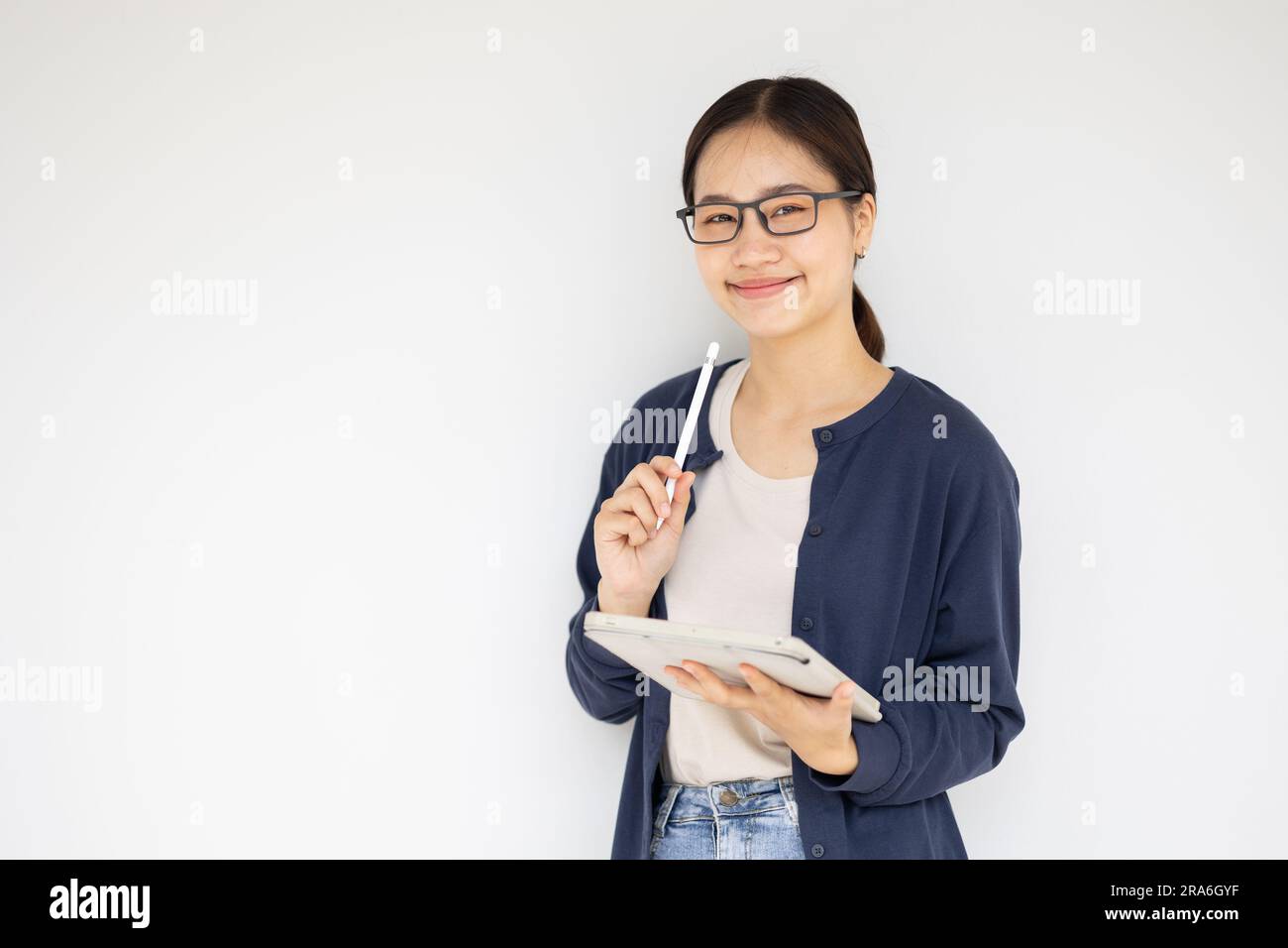 Studentessa felice adolescente asiatica sorridente rilassare l'educazione informale nell'edificio del campus universitario. Foto Stock