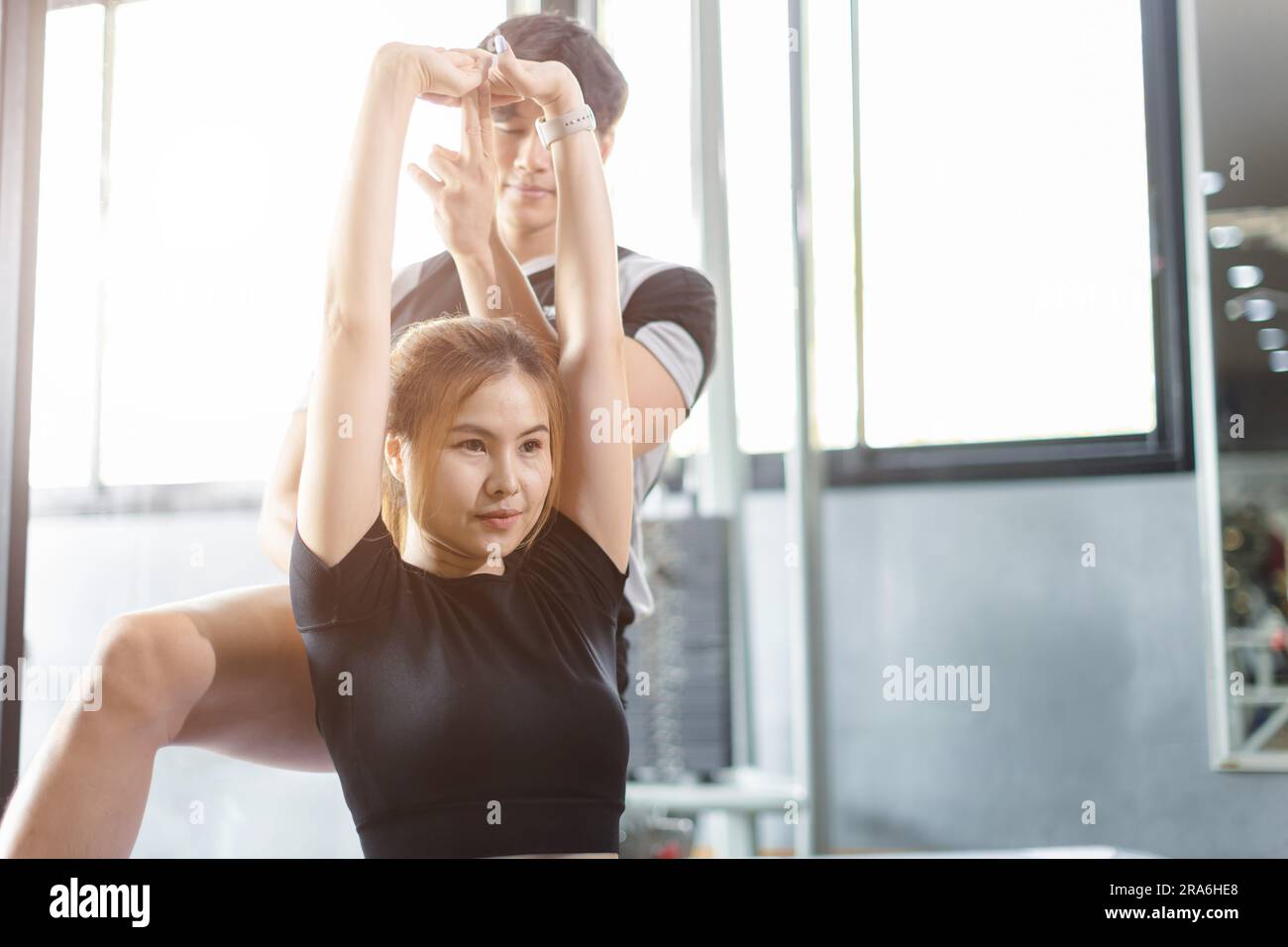 Persone sane giovani asiatiche esercitazione sportiva in palestra fitness club sportivo con personal trainer istruttori aiutano a sostenere. Foto Stock
