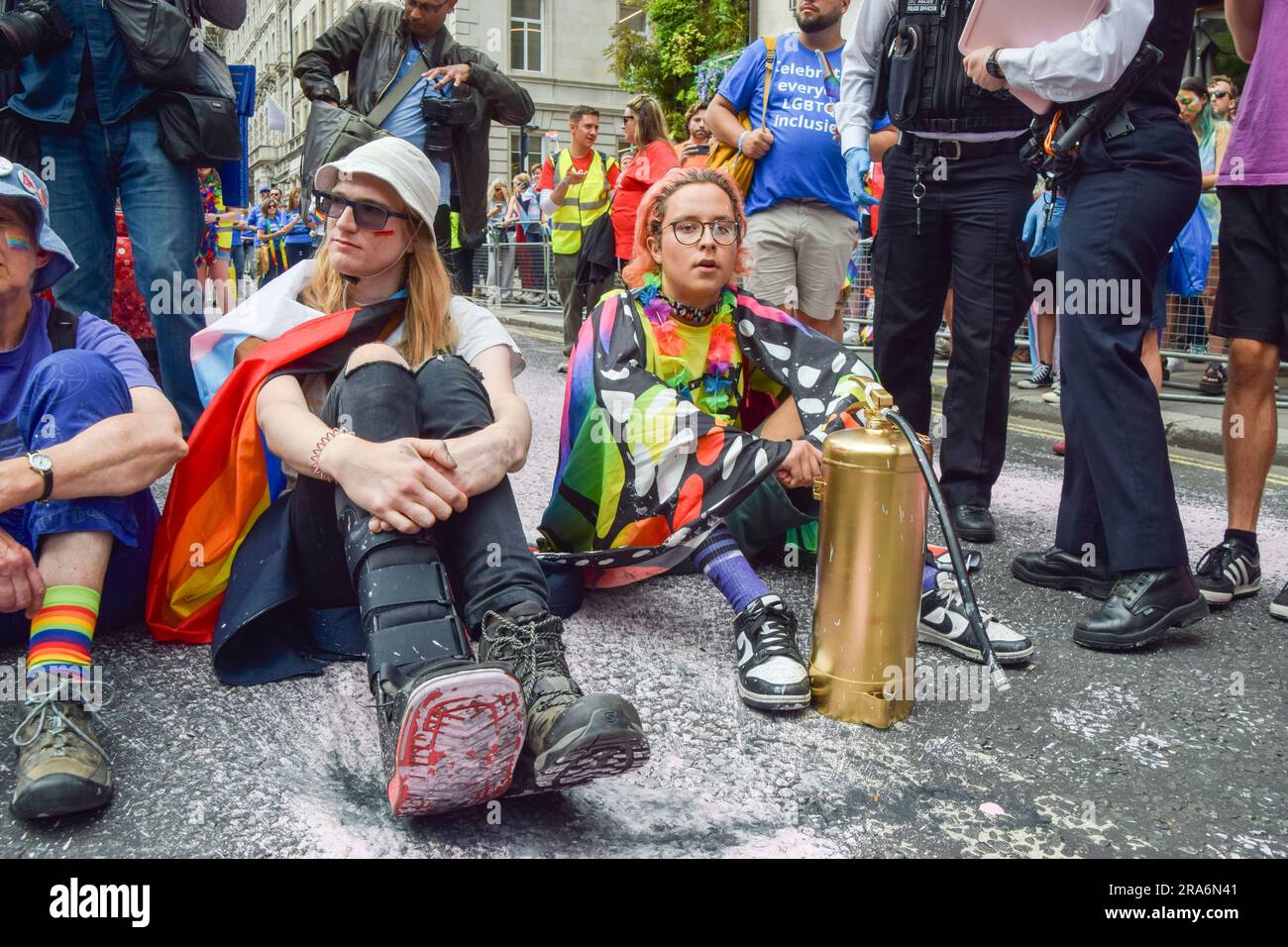 Londra, Regno Unito. 1 luglio 2023. I manifestanti si siedono e bloccano la strada durante la manifestazione. Gli attivisti Just Stop Oil della comunità LGBTQ hanno spruzzato vernice rosa e bloccato il Pride in London Parade sedendosi di fronte a un camion della Coca-Cola che partecipa alla sfilata, in segno di protesta contro la Pride che lavora con le industrie legate alla crisi climatica e in segno di protesta contro la Coca-Cola, visto come il più grande inquinatore di plastica del mondo. Credito: SOPA Images Limited/Alamy Live News Foto Stock