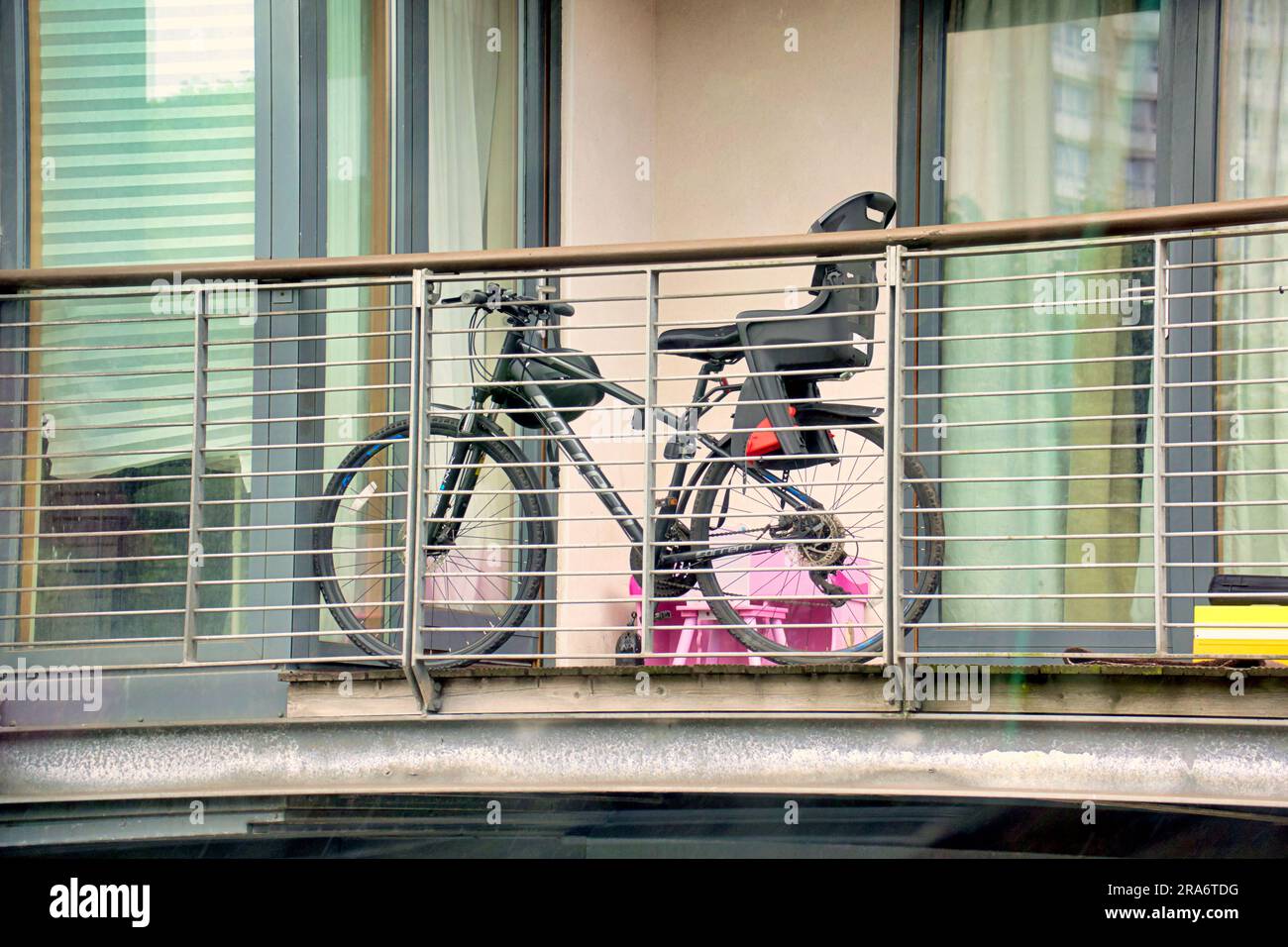 bicicletta riposta in una veranda con seggiolino per bambini Foto Stock