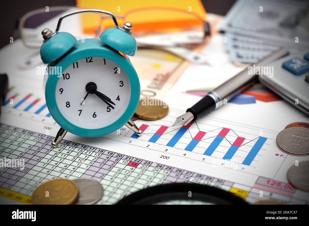 orologio, soldi e calcolatrice sul tavolo Foto Stock