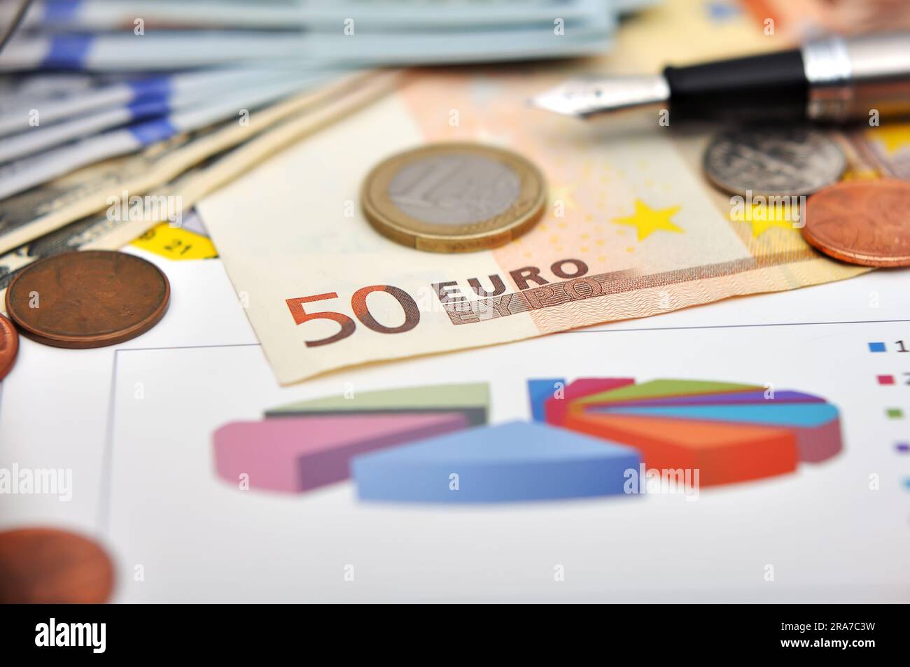 grafico sul tavolo con soldi e stilografica Foto Stock