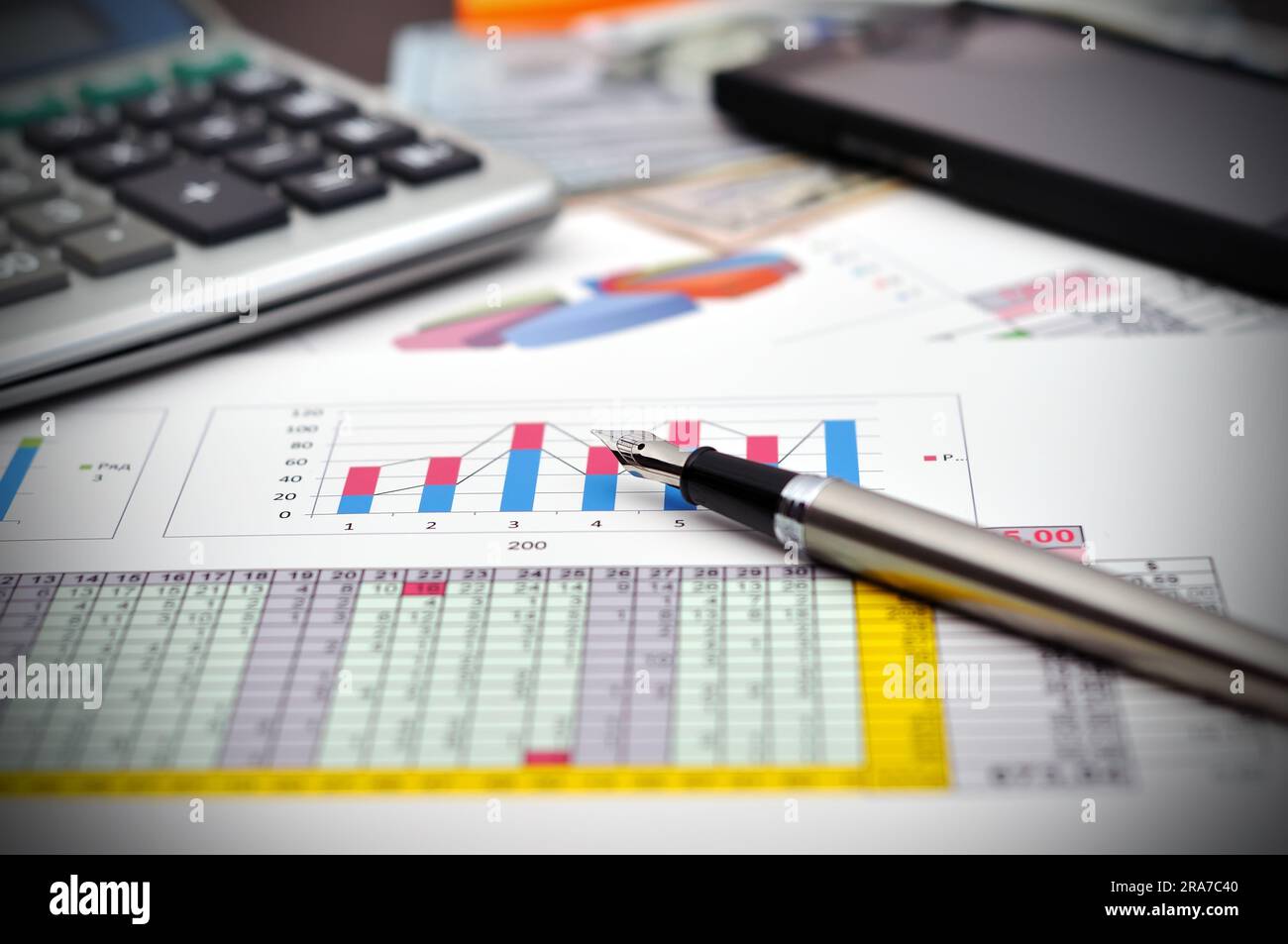 Relazione finanziaria sul tavolo con denaro, penna e telefono Foto Stock