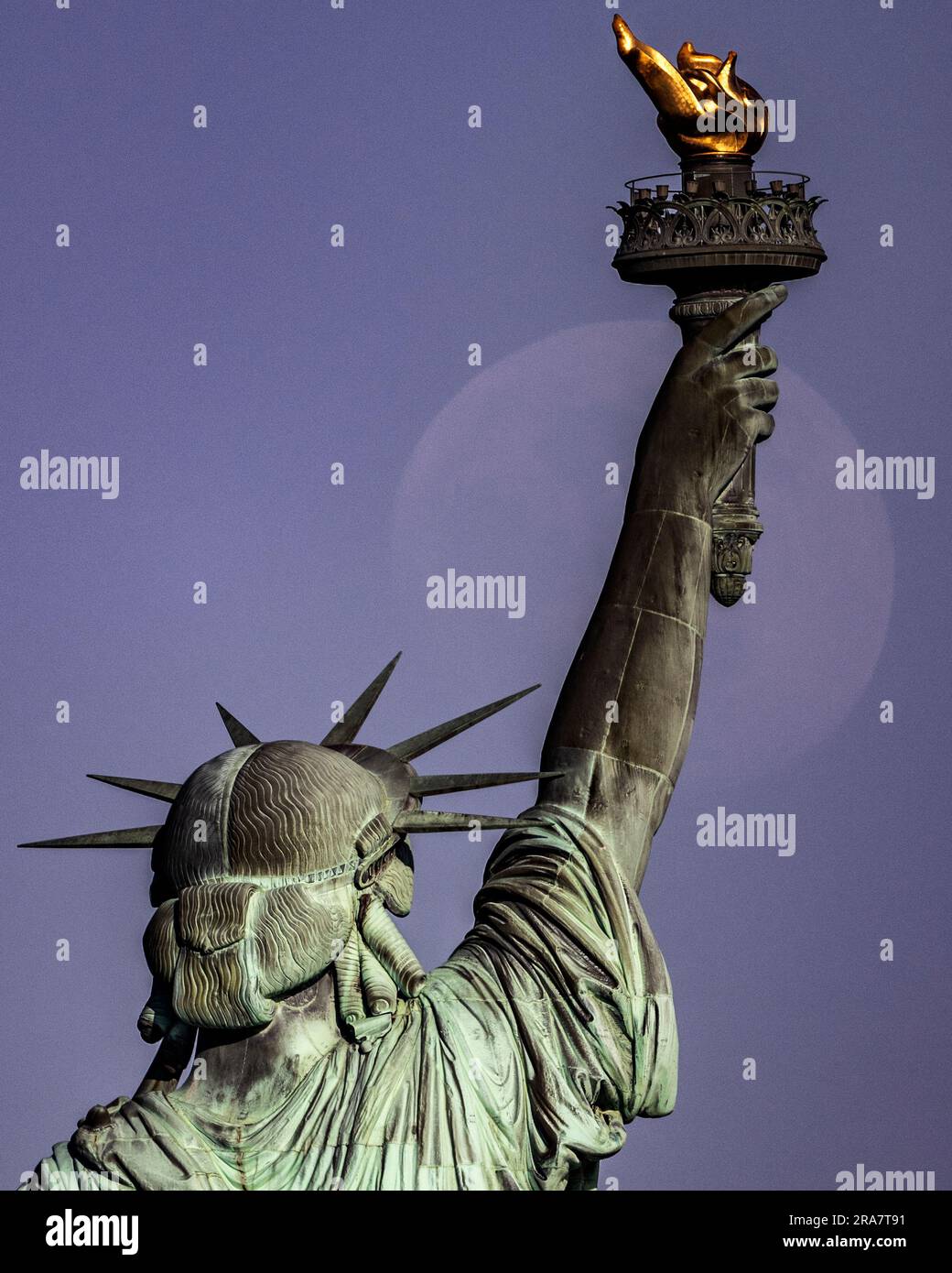 Retro della Statua della libertà con luna pallida che si innalza accanto alla torcia con dettagli nitidi Foto Stock
