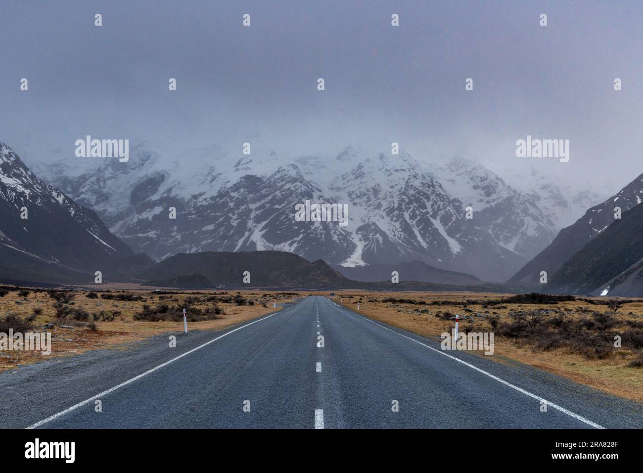 Vista panoramica lungo la Mount Cook Road, con le Alpi meridionali innevate che si crogiolano alla luce serale dell'inverno. Il miglior percorso di viaggio. Foto Stock