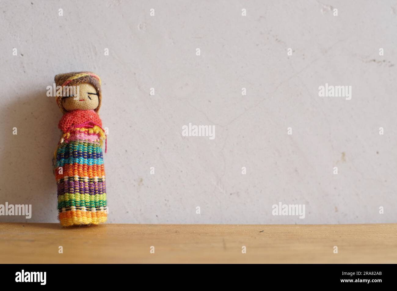 Bambola guatemalteca preoccupante o quitapene su sfondo bianco e legno Foto Stock